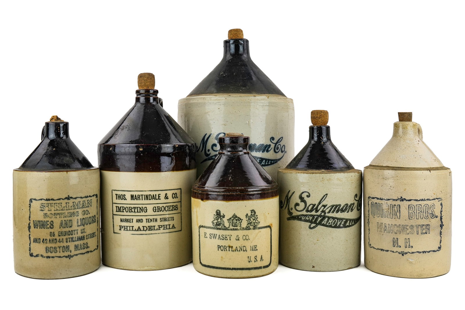 Six Stoneware Spirits Jugs: Six Salzman, Stillman, Martindale, Swasey, Quirin Bros stoneware spirits/ wine jugs- quart, half gallon, gallon, hts from 9" to 14"