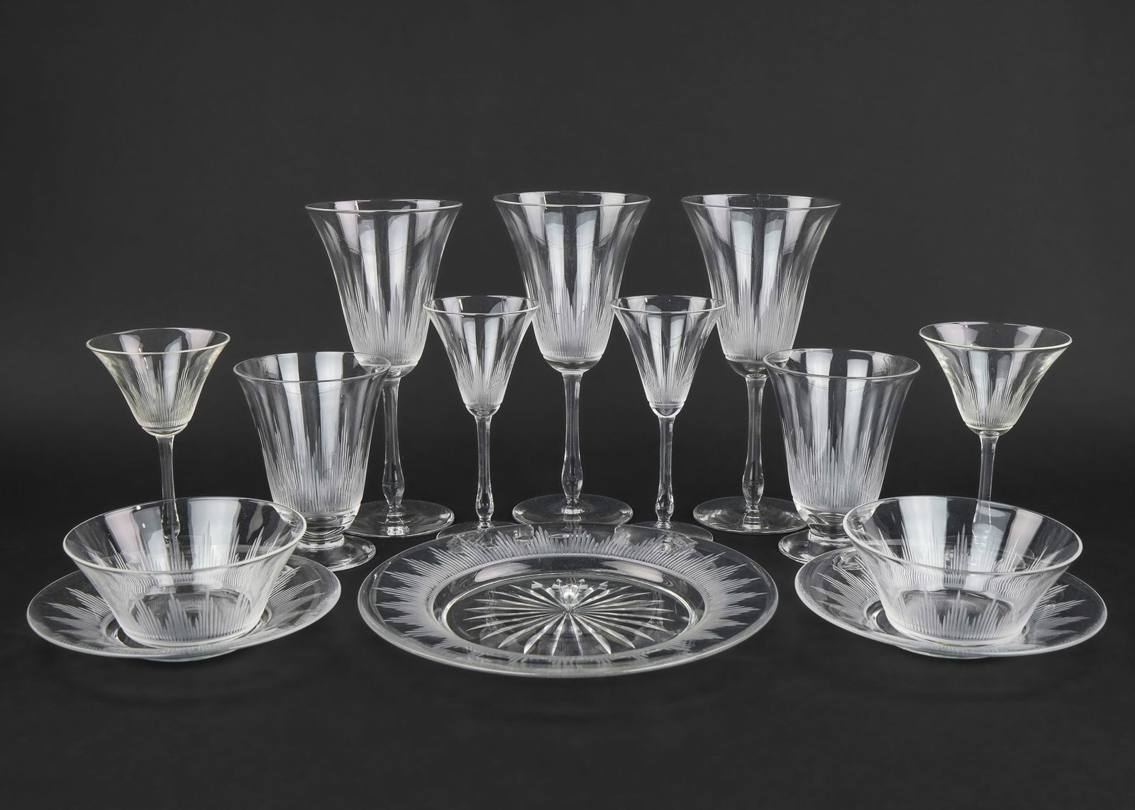 74 pcs. 1930s Wheel Etched Stemware: 74 pcs. ca. 1930's wheel etched ribbed Depression era stemware including wine goblets, juice glasses, finger bowls and under plates, aperitifs, dessert plates, etc.