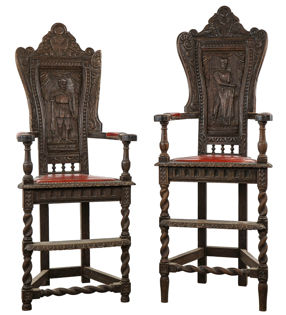 2 Oak Jacobean Revival Corner Arm Chairs: 2 oak Jacobean revival carved corner chairs. Carved family crest, back with carved full length portrait (one of a knight), rope twist legs, each with a foot rest. Red faux leather covered seats and ar
