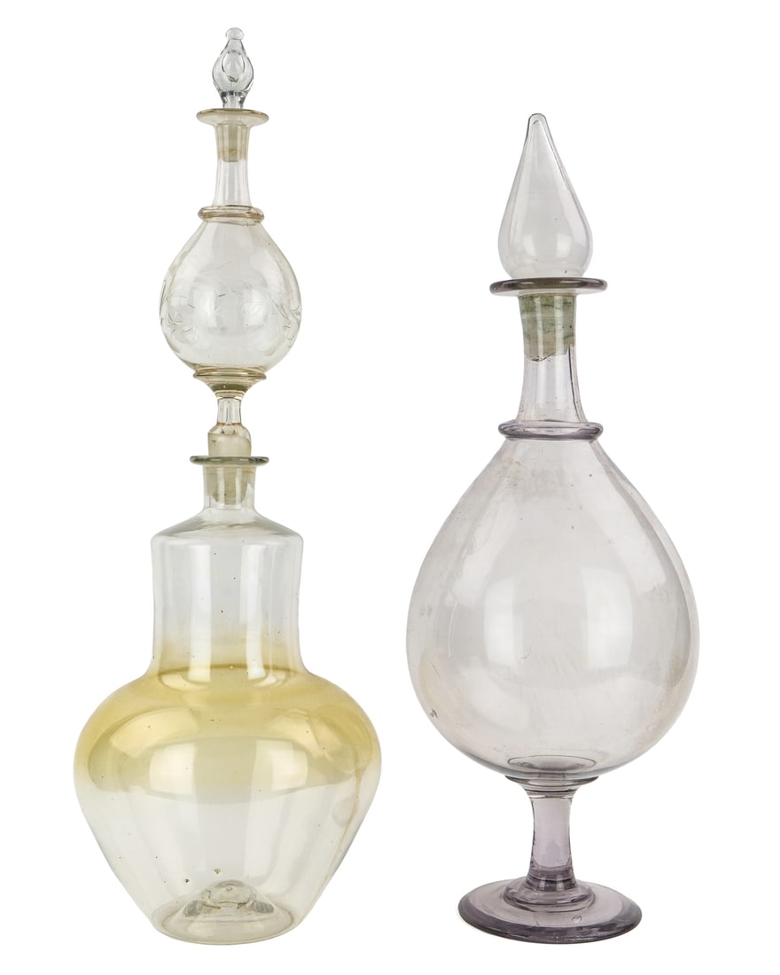 2 Blown Glass Apothecary Show Jars: Two 19th c. blown glass apothecary show jars, one having wheel engraved floral decorated final, the other having wide footed base, slightly sun purpled (mineral deposits in the finial) 25.5" x 8", 24"