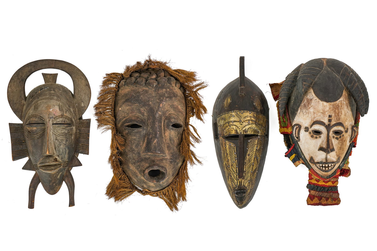 Four West African Masks: Four West African Masks - Senoufo, Bamana People mask with brass adornments, Igbo People ancestral mask with cloth covering, and a fourth West African mask of unknown origins. (Possibly Dan People) wi