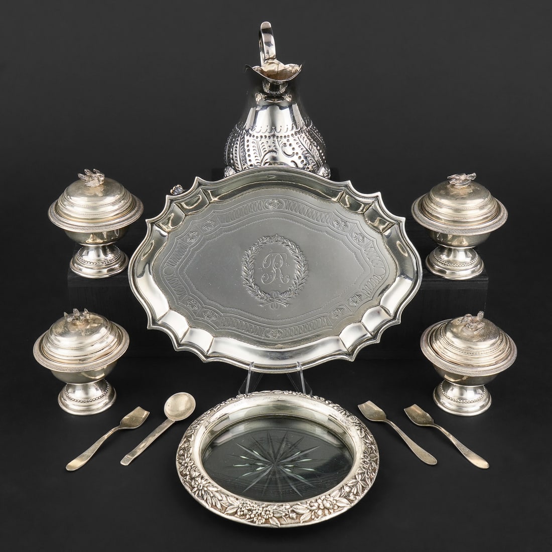Group of Small Sterling Silver Table Accessories: Group of small silver table accessories including a set of 4 Egyptian salt cellars with figural bird handled lids and 4 assorted salt spoons, Kirk repousse sterling banded cut glass bottle coaster, 18