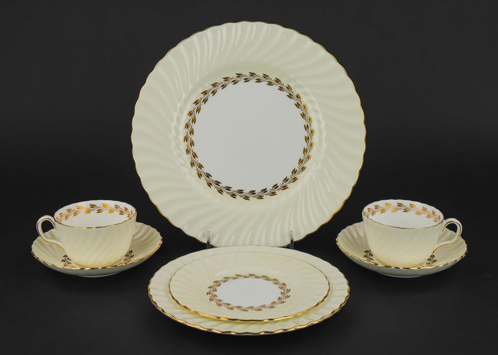 77 pcs. Minton Cheviot Porcelain Dinnerware: 77 pcs. Minton "Cheviot" pattern gilt laurel and fluted English bone china porcelain dinnerware including dinner plates, luncheon plates, side bowls and plate, cups and saucers, etc. all in excellent