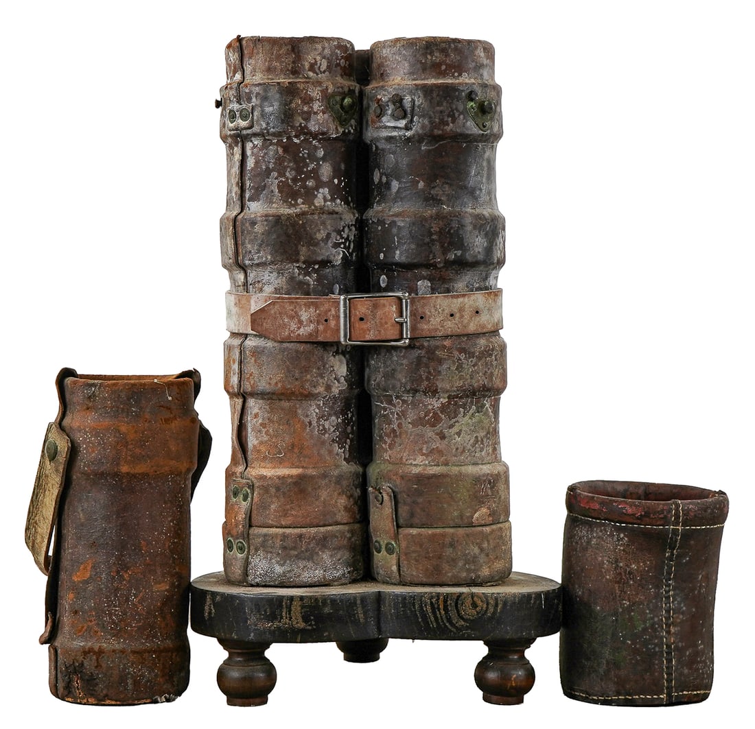 WWI Leather Shell Case Carriers: Three WWI artillery leather shell case carriers, bound together as an umbrella stand, overall ht 28 3/4", sold with a smaller shell case carrier with British Naval cot of arms and a small fire bucket