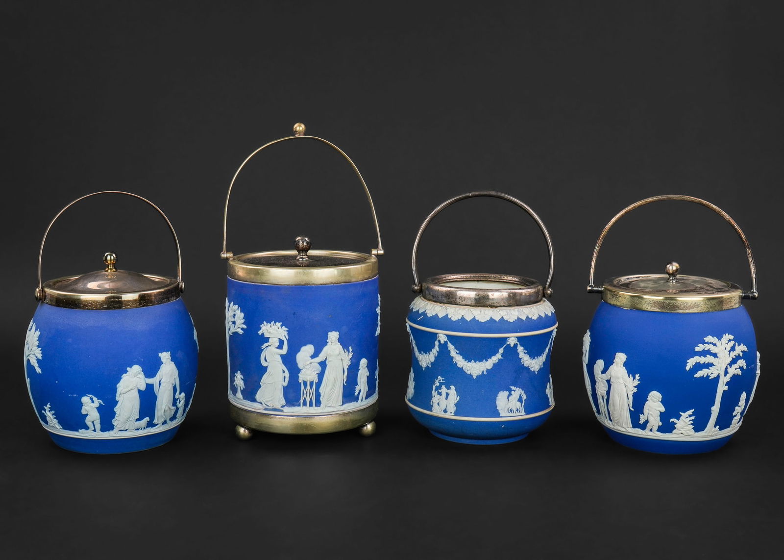 4 Wedgwood Jasperware Biscuit Jars: Group of 4 Wedgwood cobalt blue dipped Jasperware biscuit jars, one missing lid having significant damage and repairs, one of the barrel form jars with side damage and repairs, some wear to silver pla