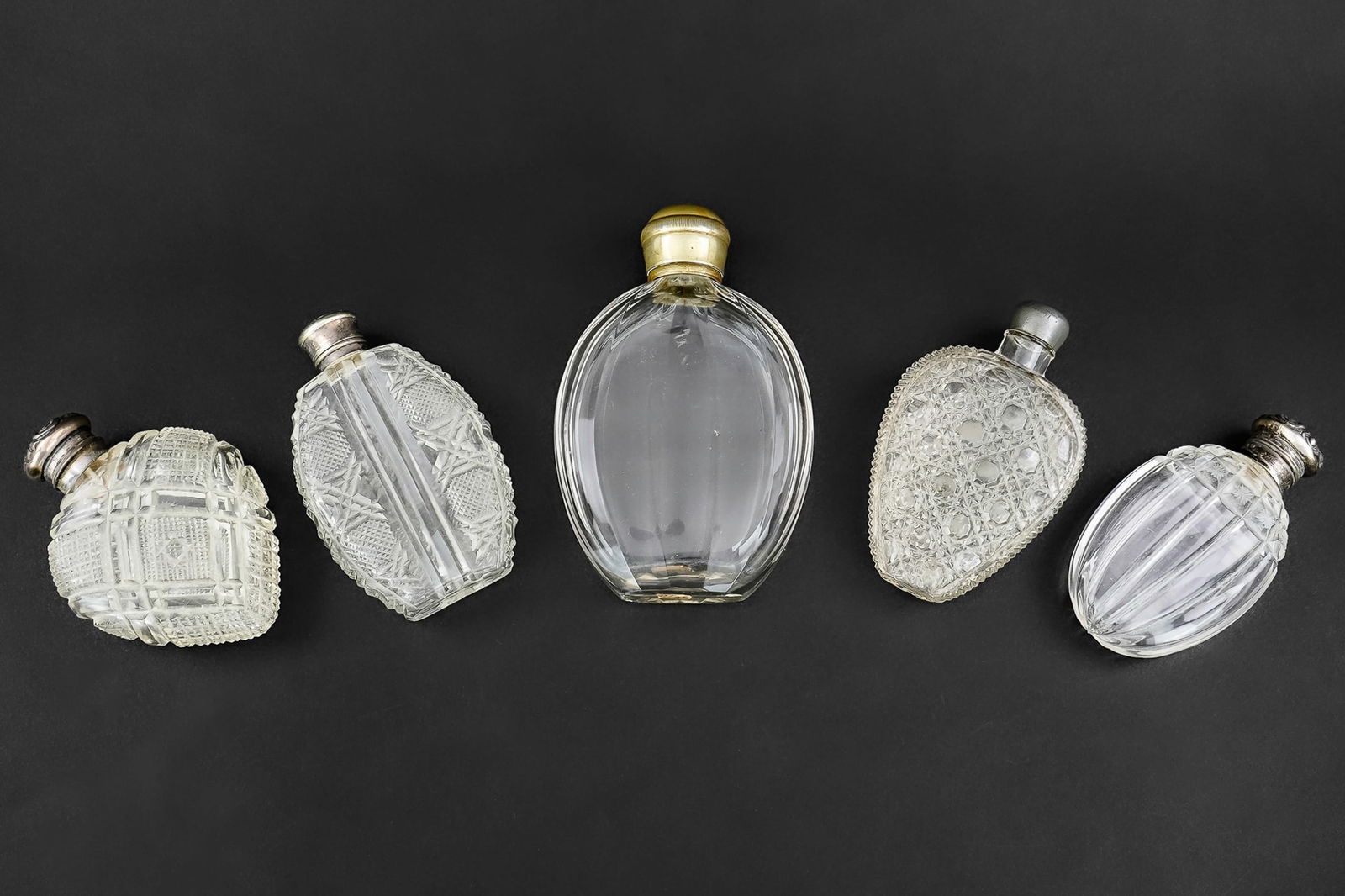 5 Victorian Era Glass Pocket Flasks: Group of 5 Late Victorian/Edwardian era glass pocket flasks including brilliant cut, pressed, paneled cut, some with sterling, pewter, and plated caps, some wear, overall good condition 4"-5.5"