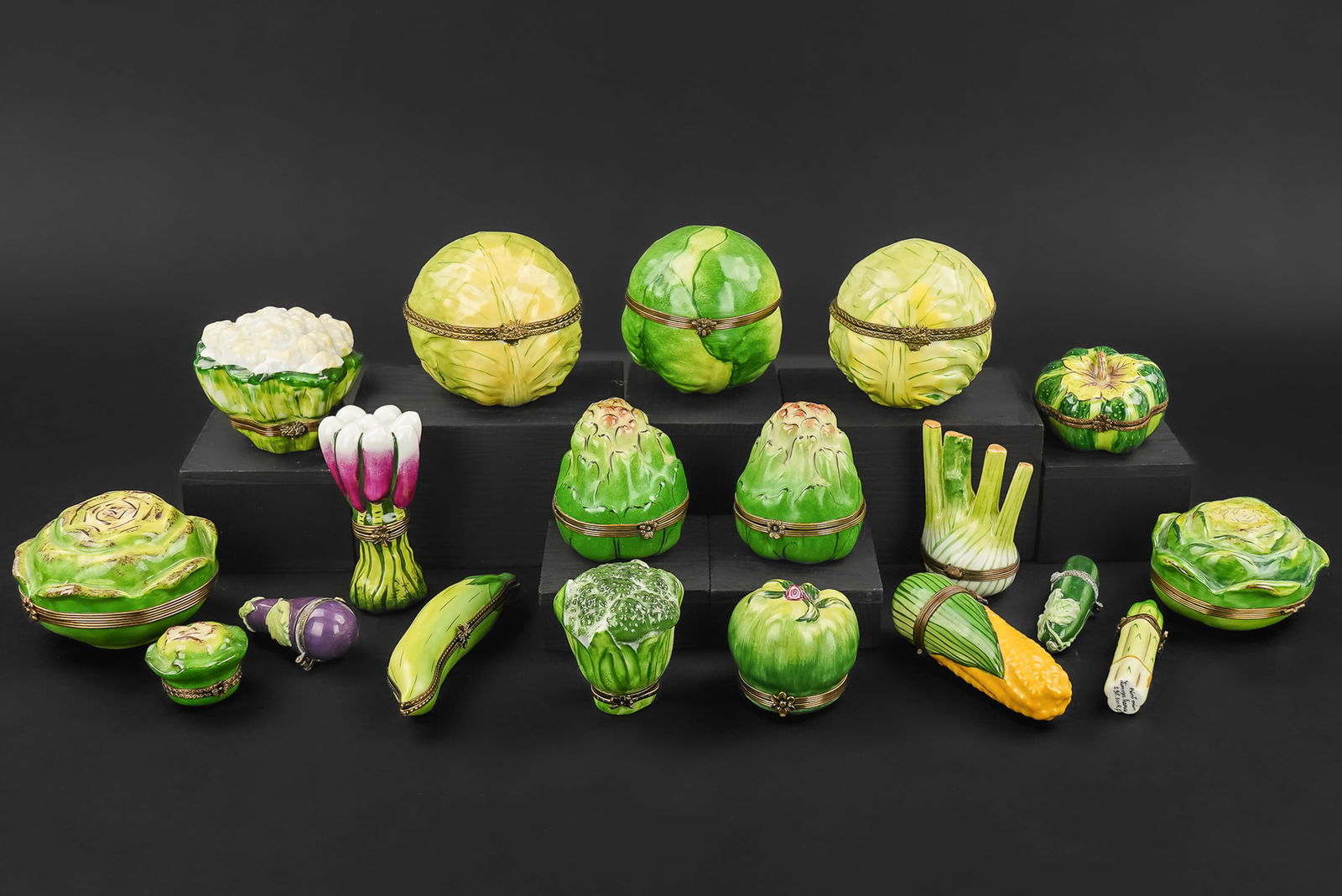 Limoges Porcelain Vegetable Form Pill Boxes: Collection of 19 Limoges porcelain vegetable form novelty figural pill boxes with hand painted decoration including cabbages, peas, eggplant, corn, leeks, radishes, artichokes, squash, asparagus, etc.
