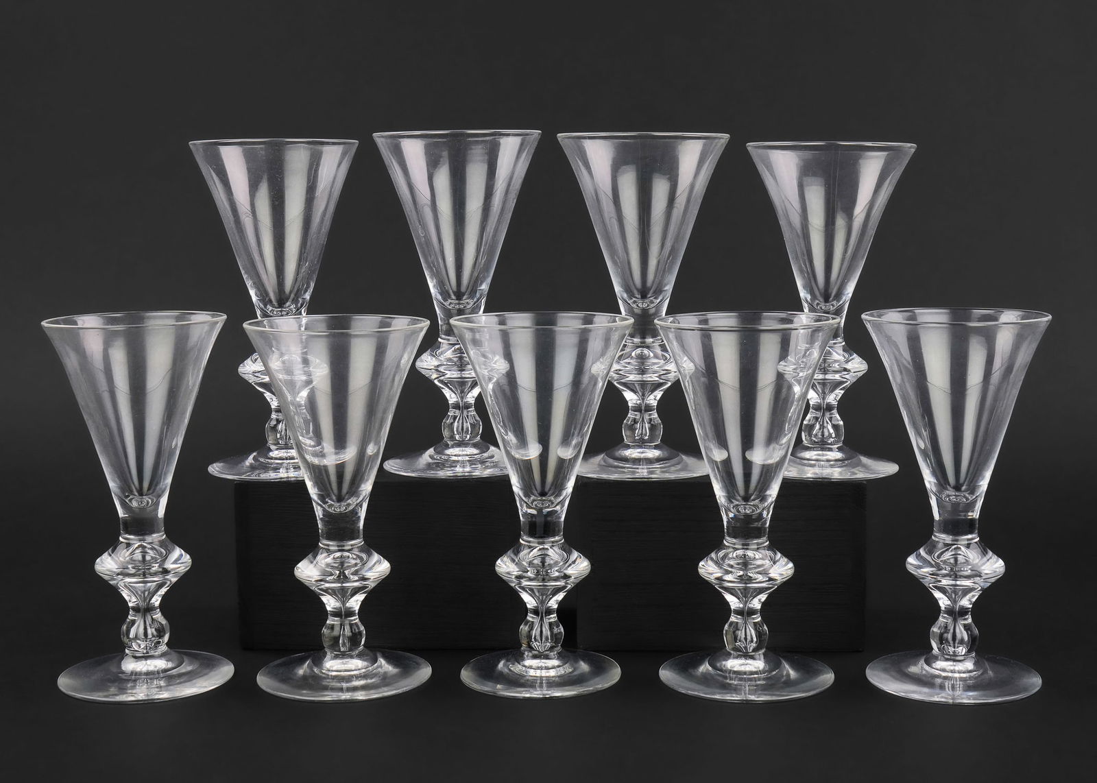 9 Steuben Knob Stem Crystal Goblets: Set of 9 fine Steuben mid century blown crystal trumpet form knob stem goblets, each retaining original felt storage bag, signed under base, excellent overall condition 3" x 6"