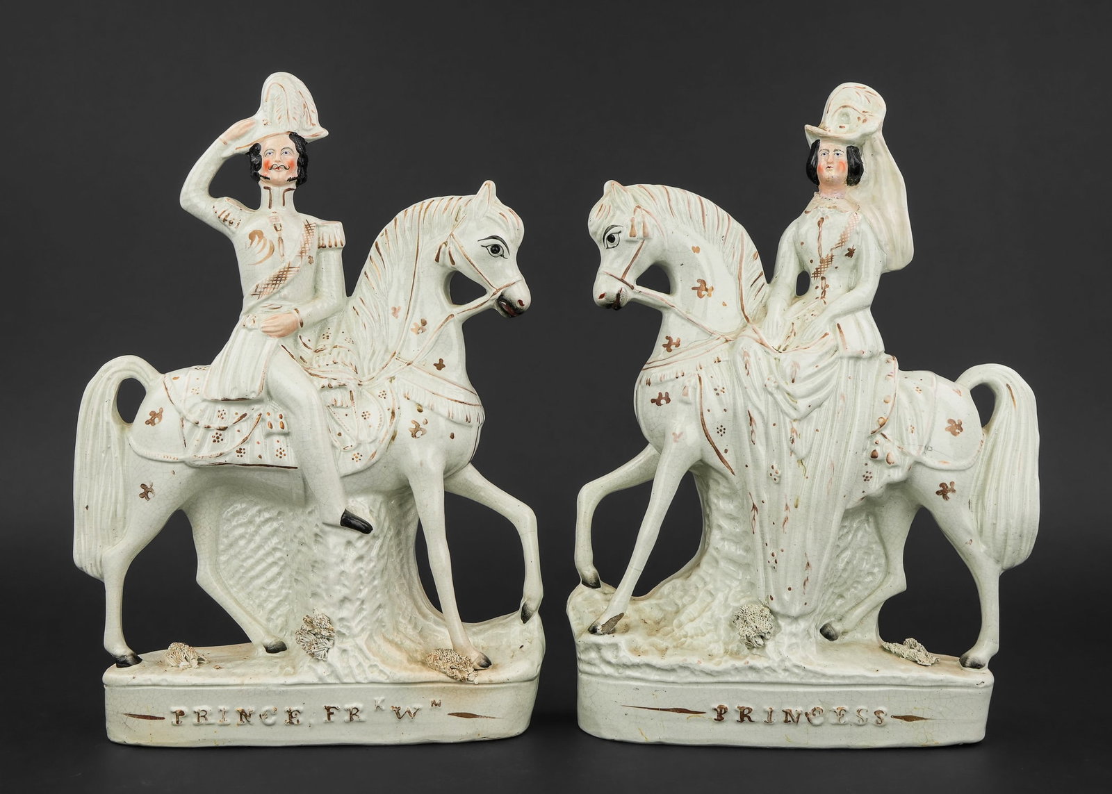 Pair of Staffordshire Pottery Equestrian Figures: Pair of 19th c. English Staffordshire pottery equestrian figures depicting "Prince Frederick William" in military uniform riding horseback and "The Princess" riding side saddle 14.5" x 10" -female fig