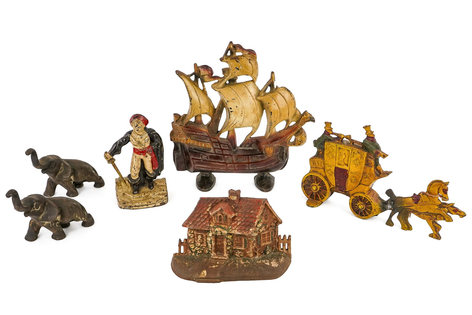 6 Cast Iron doorstops bookends: Six cast iron doorstops and bookends- Cold painted Pirate bookend or doorstop 7", Cottage doorstop 5.5" tall, Pair of elephant bookends 5", ca 1960 carriage doorstop 12" long (Repaired) 1930's Santa M