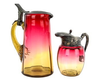 Two Victorian Amberina Glass Pitchers with Metal Lids