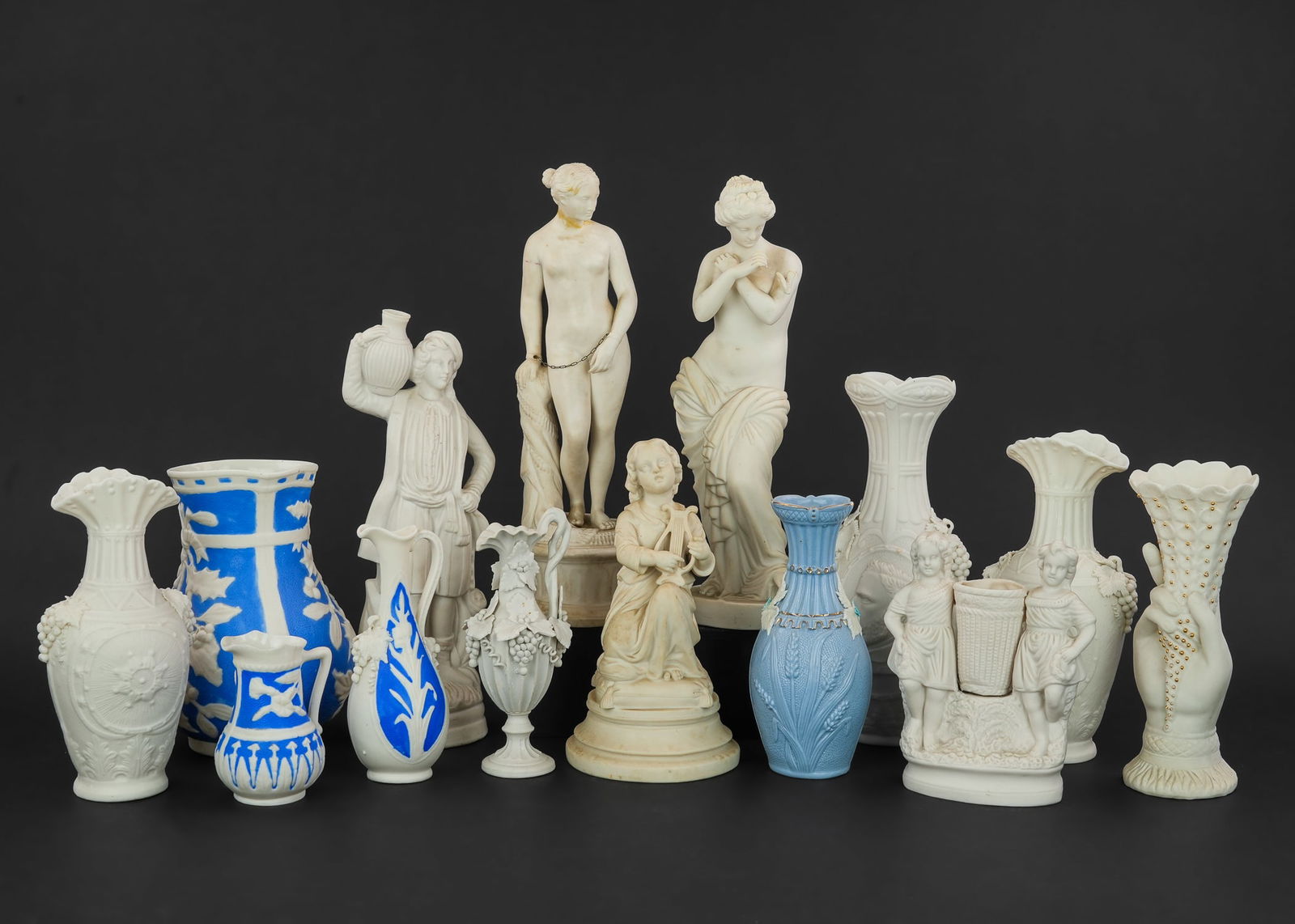 Collection of 14 pcs. Parian Bisque Porcelain: Collection of 14 pcs. of mid 19th c. Parian bisque porcelain including Bennington pitcher and other items, mantel figures, female nude of Roman slave (neck damaged) -some imperfections ht. 4"-13"