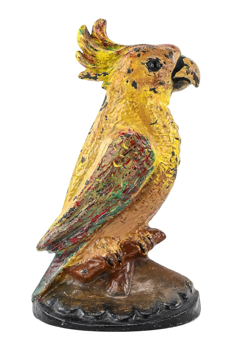 Art Deco Parakeet Cast Iron Doorstop: Cast iron doorstop in the form of a yellow parakeet with red and blue wings on a black base, marked “1930” on the back. Retains original paint with light wear. Measures approx. 8" tall x 6" wi