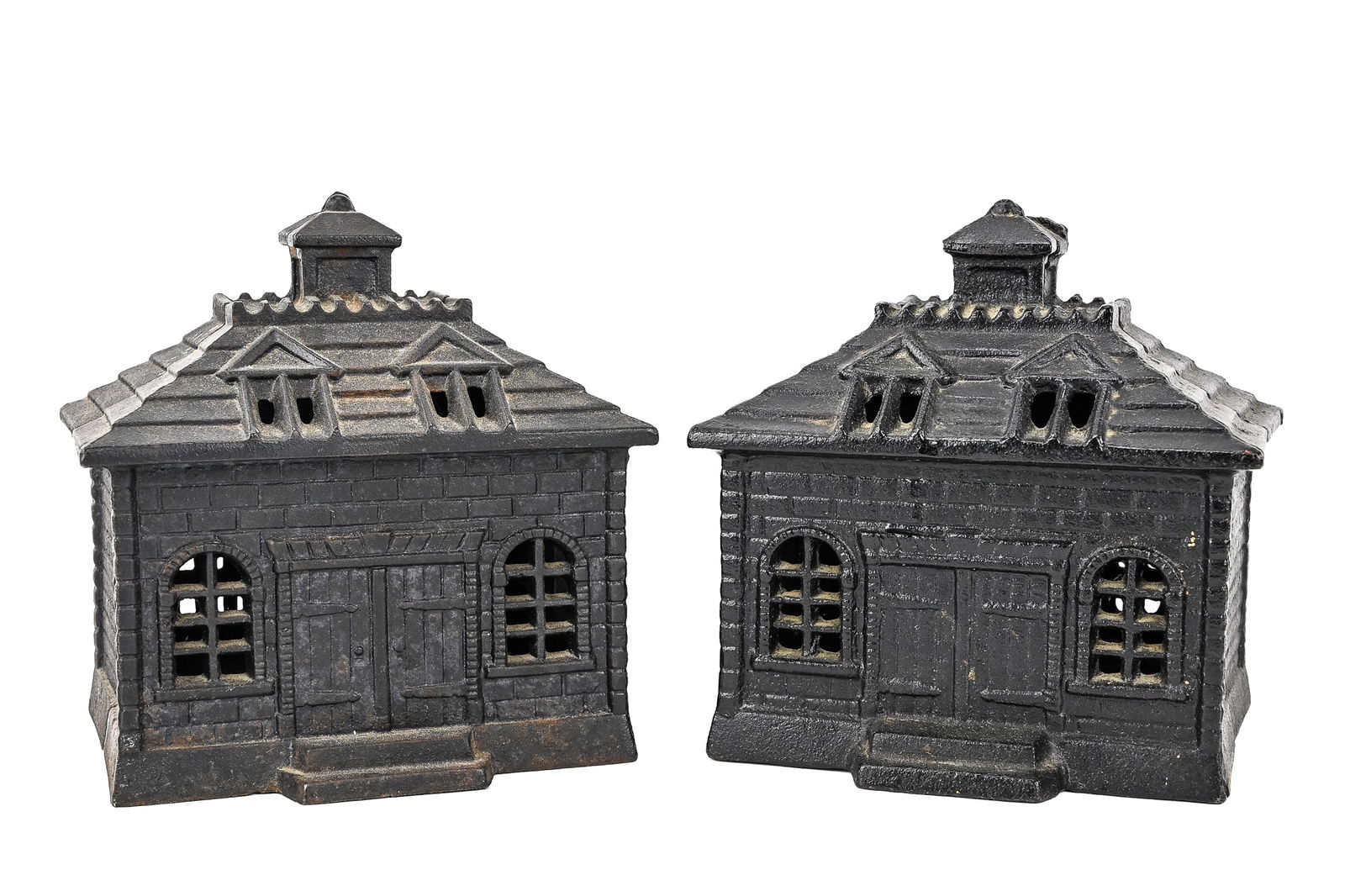 Pair of John Wright Cast Iron Banks: Pair of John Wright still banks, each with double entry doors, cupola roof, and window details, finished in black cast iron. Made in the 1960s. Each measures approx. 5" x 6" x 4".
