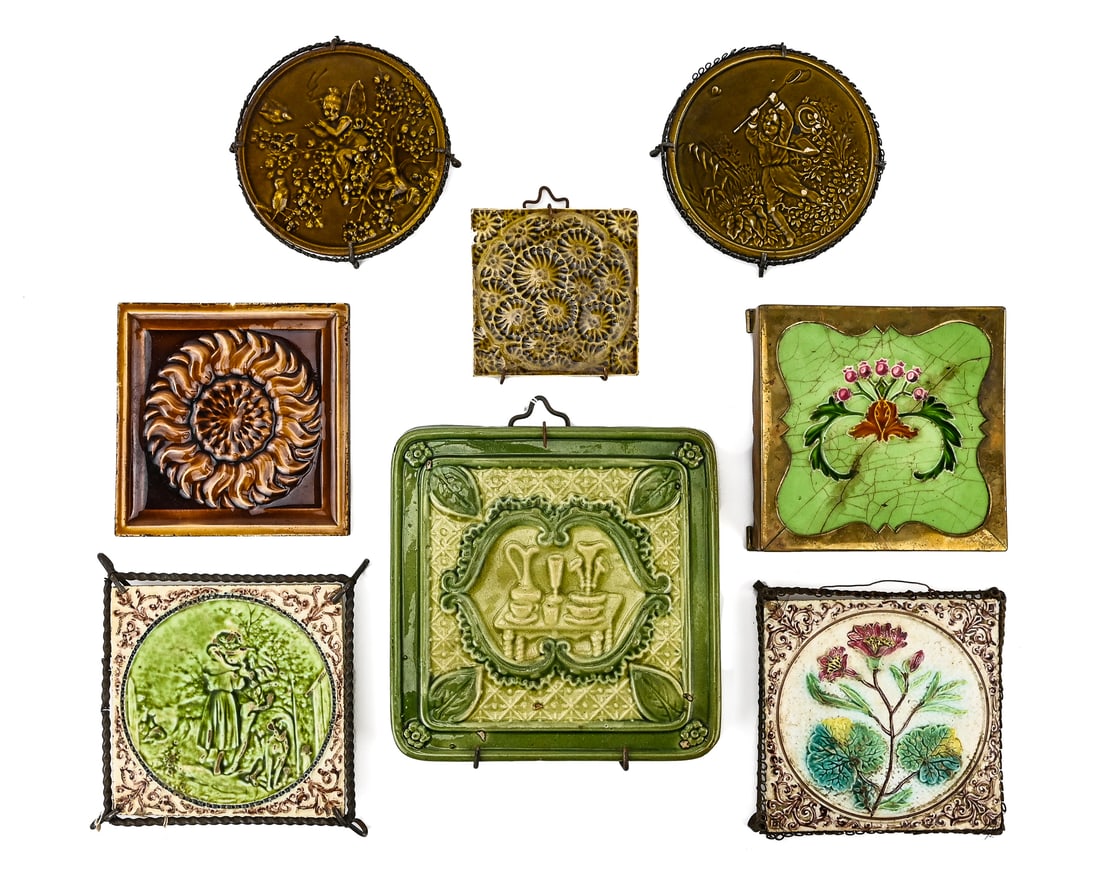 Porcelain Tile Trivets (8 pcs): Group of eight porcelain tile trivets, some with metal or brass stands. Includes a brown flower tile marked J.J. Glow, Patent Chelsea, Mass., 6" L, a repetitive layered flower pattern tile also marked