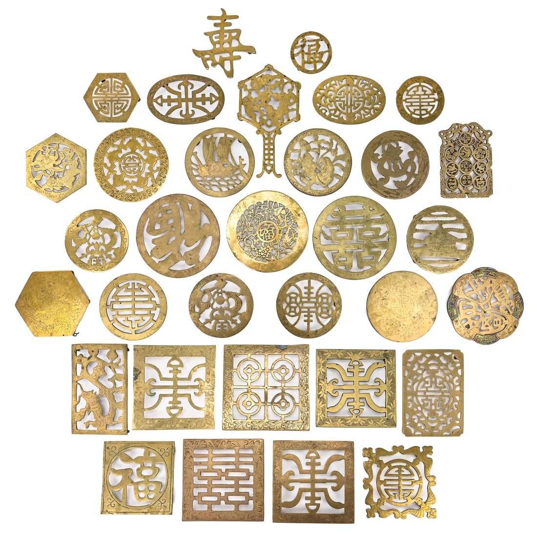 Brass Asian Trivets (33 pcs): Group of 33 brass trivets with Asian-inspired engravings, featuring depictions of flowers, ships, and other decorative motifs. One includes remnants of enamel paint on portions of the sides. Most reta