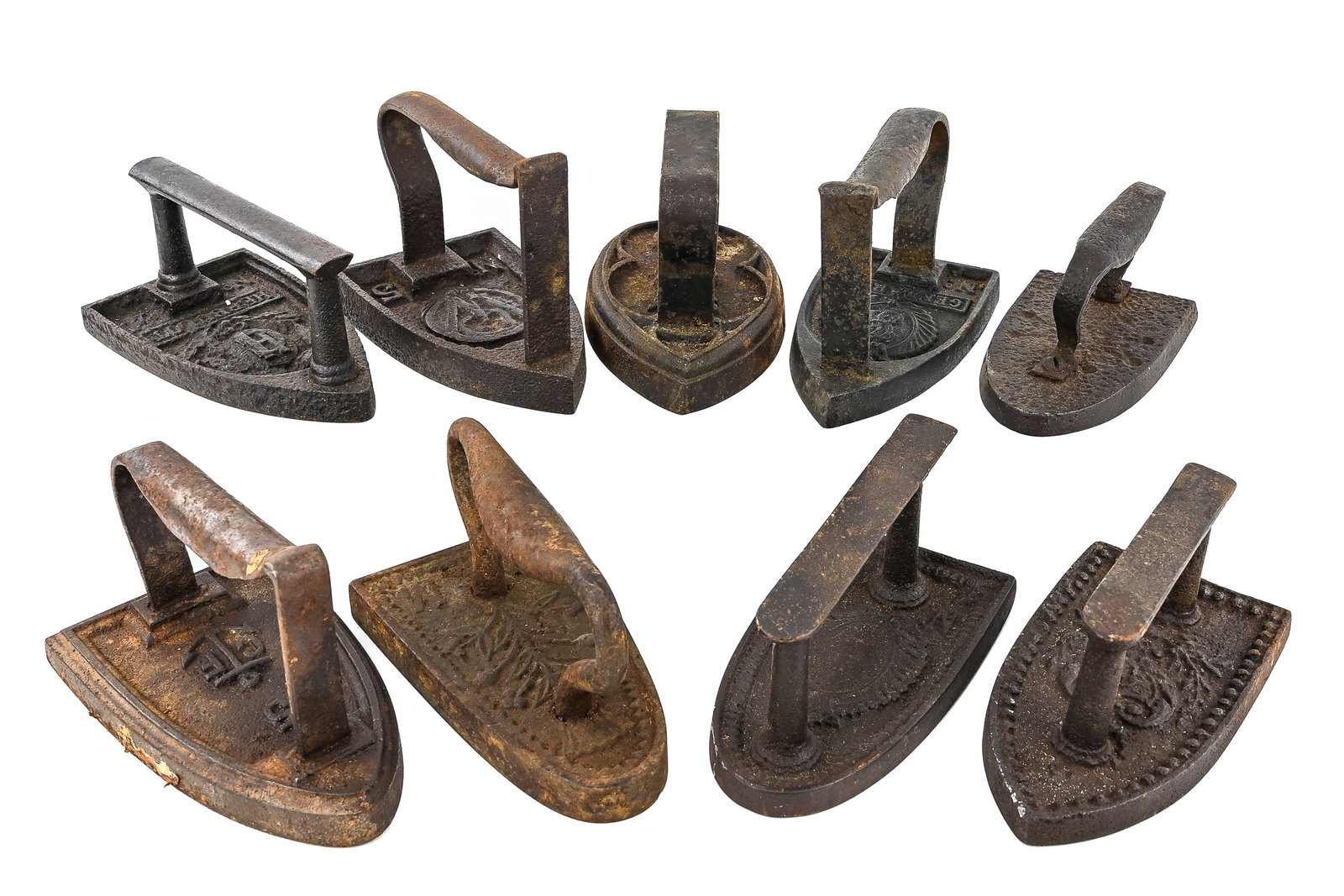 Cast Iron Sad and Flat Irons (9 pcs): Group of 9 cast iron sad and flat irons, historically heated on a fire to press clothing. Each measures approximately 7" L x 4" W and shows signs of age and use consistent with vintage irons.