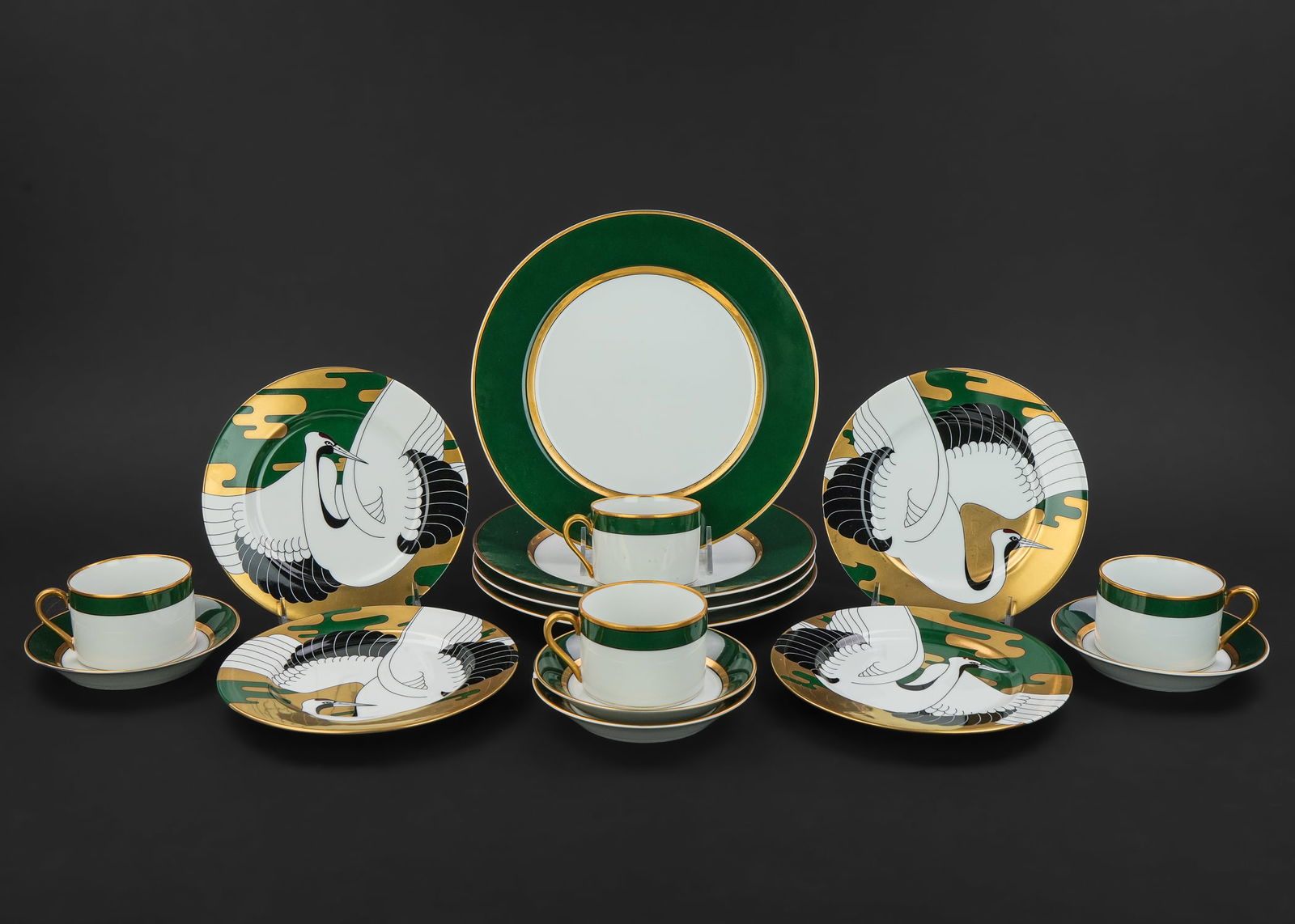 Fitz and Floyd Renaissance Porcelain Dinnerware: 12 pcs. Fitz and Floyd "Renaissance" pattern 1978 forest green and gold banded dinnerware including cups and saucers, and dinner plates, accompanied by 4 Fitz and Floyd "Golden Tancho Stork" accent pl