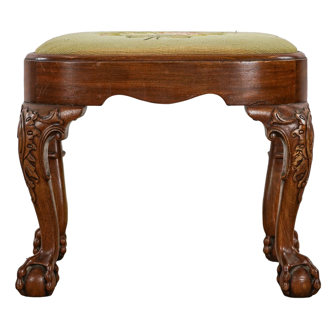 Goddard and Townsend inspired footstool: circa 1900 Goddard and Townsend inspired mahogany footstool with pierced ball and claw foot, foliate carving at knees, needlepoint upholstery 1960's era refinish. 17 x 21 x 15"