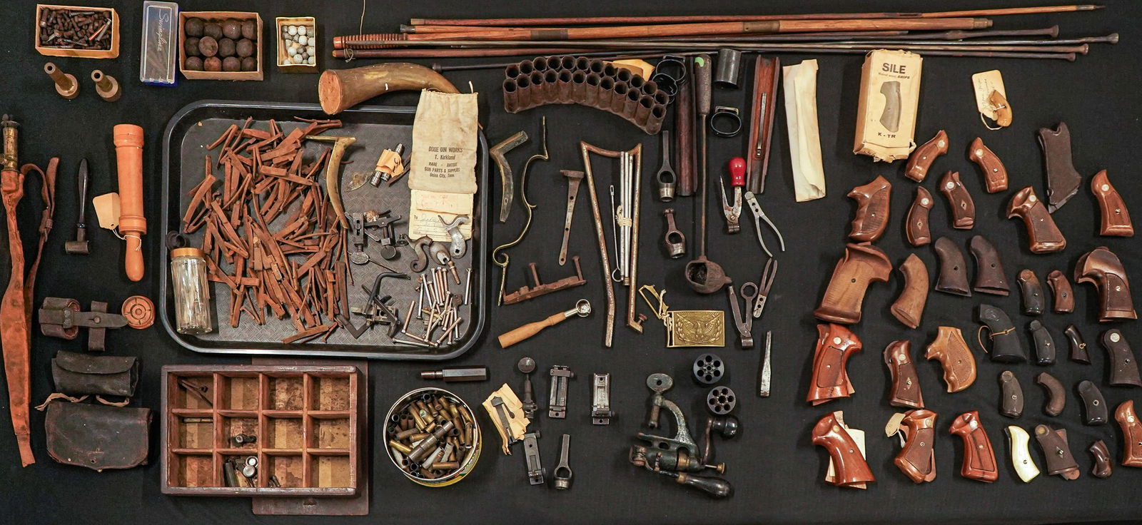 Antique Firearm Parts & Tools: A group of antique firearm parts and tools including ram rods, 18th c ram rods, trigger springs, early cannon shot, pistol bullet molds, leather belt box, hammers, cylinders, flip sights and peep sigh