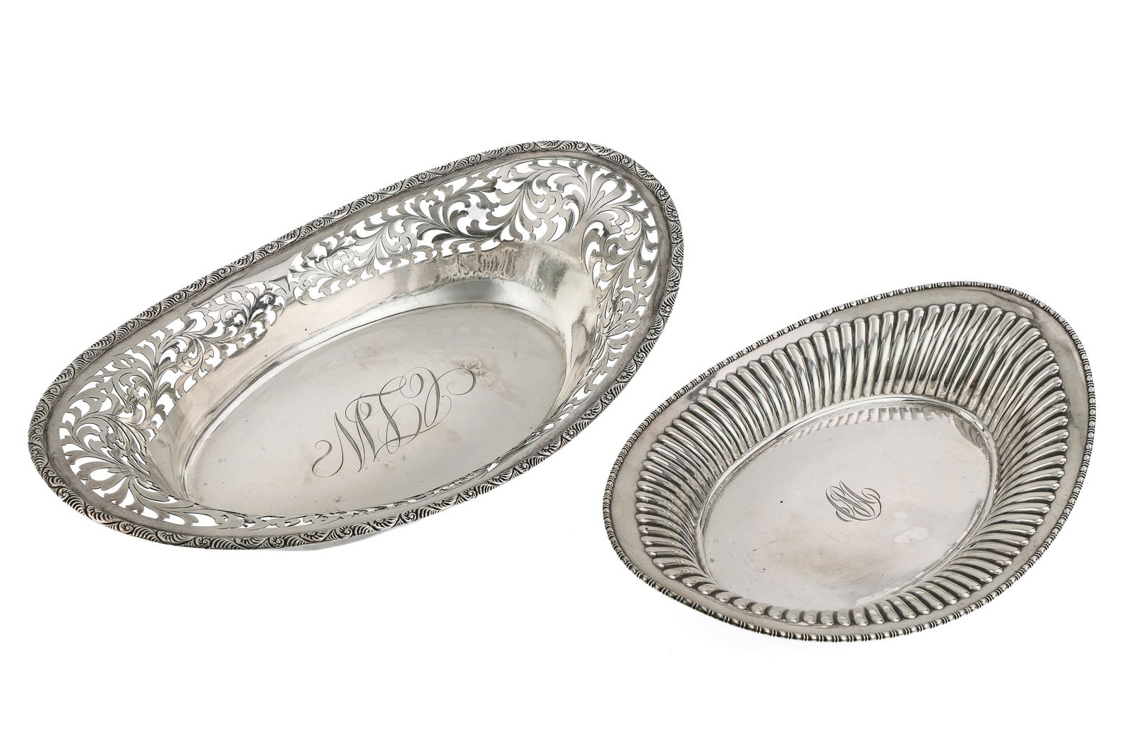 Two Sterling Silver Oval Bread Trays: Two Edwardian era sterling silver oval bread trays; one larger reticulated tray retailed by J.E. Caldwell and Co. of Philadelphia, one smaller fluted by Meriden Britannia Co. 10.5"-12.75" long 21.9