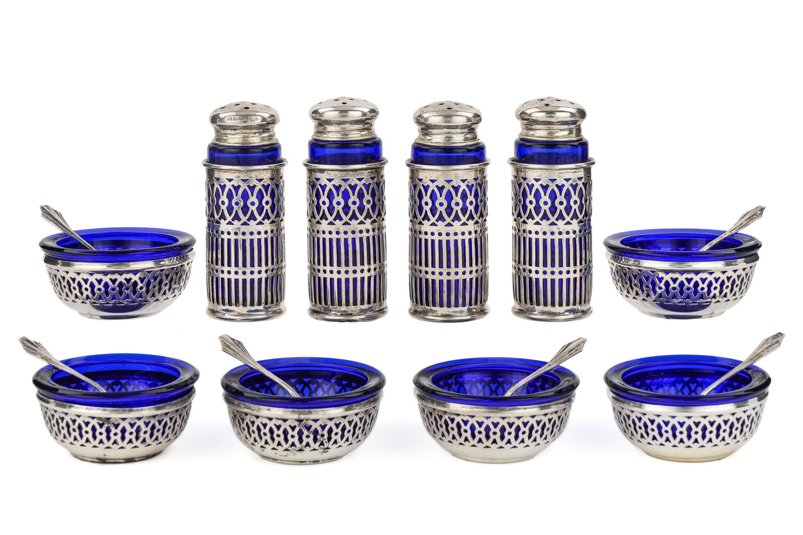 Sterling Silver Salt Cellars and Pepper Pots: Set of 6 Webster sterling silver reticulated salt cellars with cobalt blue glass liners and matching spoons, accompanied by 4 matching pepper pots. 3.4 ozt.