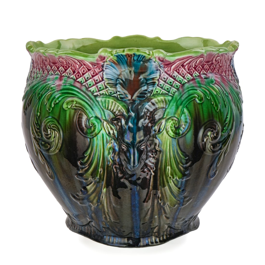 Majolica Pottery Oversized Jardiniere Planter: ca. 1900 Victorian art pottery majolica glazed oversized jardiniere planter having embossed figural rams head decoration, with shell and lattice work scalloped rim, and musical instruments. Bold