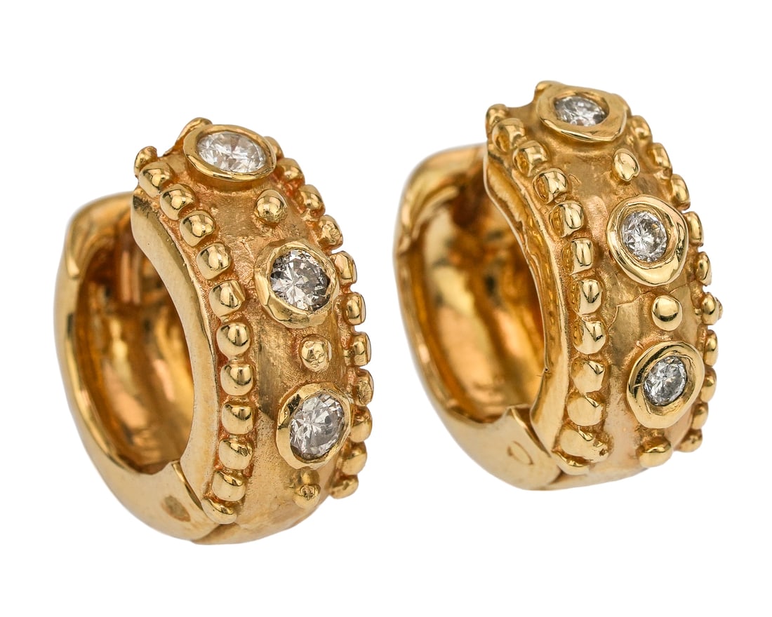 Diamond & 14k Hoop Earrings: A pair of 14k yellow gold earrings each set with 3 round cut .05 ct diamond in a bezel set. 1/2" diameter. 7.1 grams t.w.