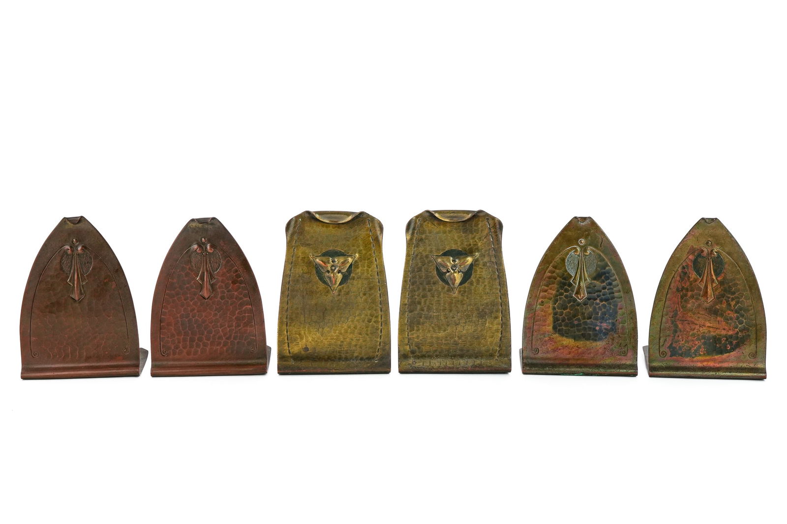 Roycroft Trefoil, Trillium Bookends: Three pair of Roycroft "Trefoil", "Trillium" bookends (6 pcs), including trillium pr in brass finish, trefoil pr in Aurora finish, and a trefoil pr in brass finish, mid to late Roycroft orbs, hts 5"