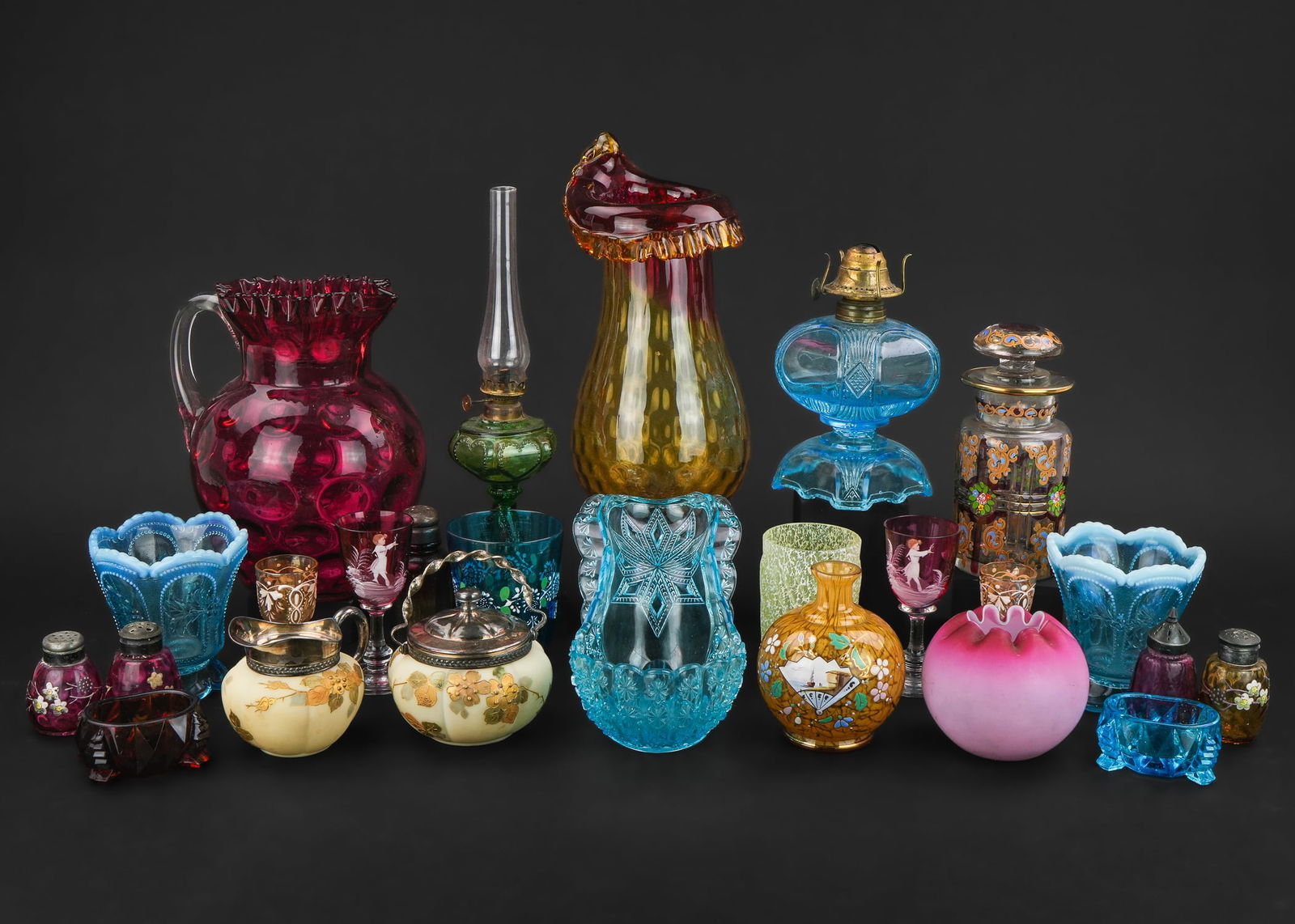 25 pcs. Victorian Colored Art Glass Tableware: Collection of 25 pcs. of Victorian colored art glass tableware including Amberina 'Jack in the Pulpit' vase, emerald miniature sweetheart lamp, rare blue Daisy and Button 'Sitz Bath' novelty dish,