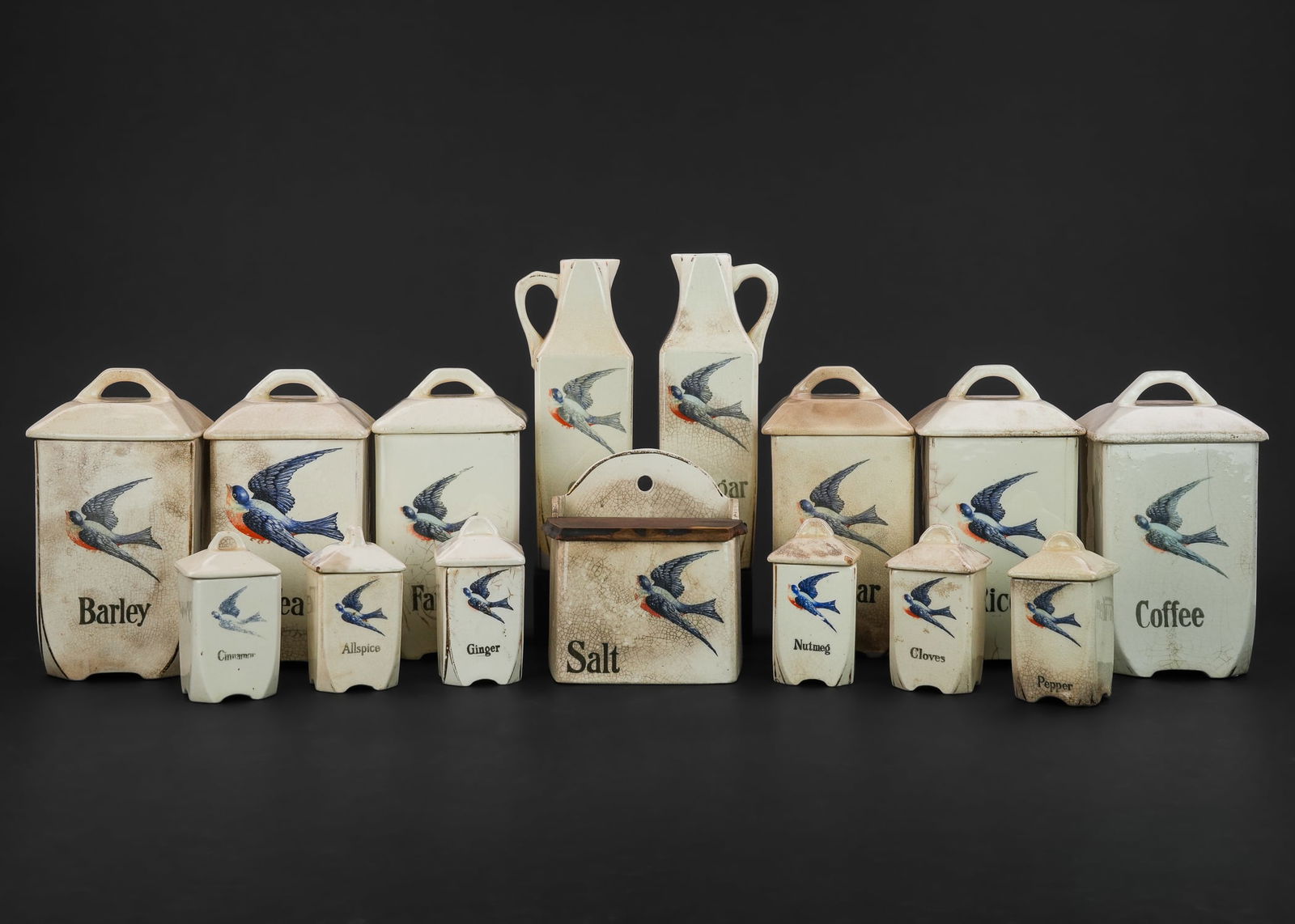 1920s German Ceramic Blue Bird Canister Set: 15 pc. 1920s German ceramic kitchen canister set with bluebird transfer decoration, some crazing, cracks, repairs and imperfections.