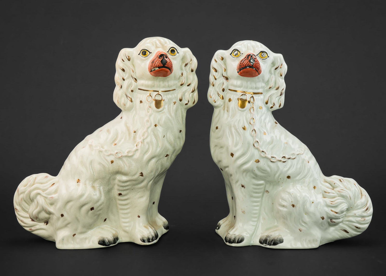 Pair Staffordshire Chain Dogs: 19th c Pair of white Staffordshire chain dogs with gilt chain, lock, and orang nose. Approx. 12" h x 9" x 3". Good condition, some wear to color.
