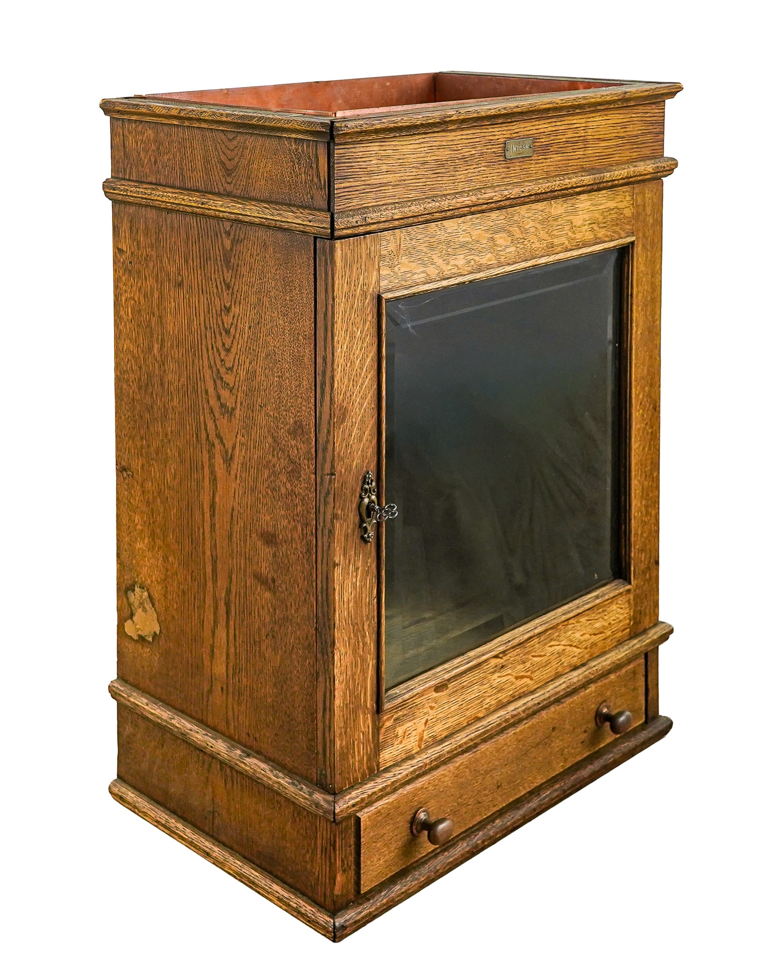 Oak beveled Glass Door Cabinet: Ca. 1900 oak hanging cupboard with single beveled glass door, lower drawer, and top with inset copper tray. Brass tag on front "INTOSH CHICAGO". 19"w x 12"d.x 26" h. Has working key for lock.