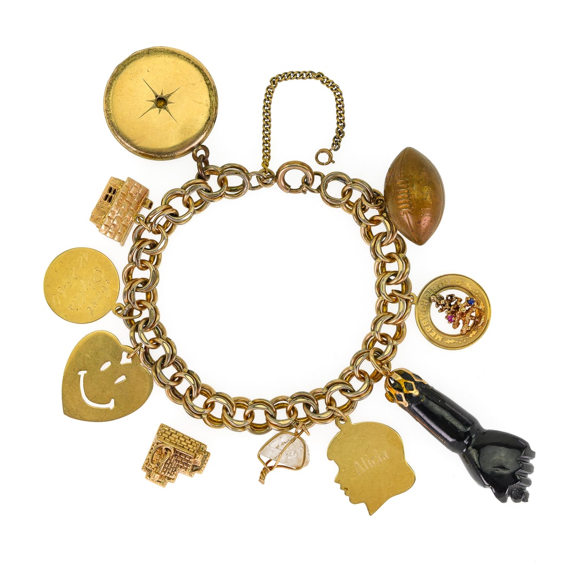 Yellow Gold Charm Bracelet: A gold plated chain bracelet with charms including a 10k house, 14k house with pill box roof, 14k christmas tree round, 3 flat 14k charms, onyx fist fob / charm, and a gold plated locket.