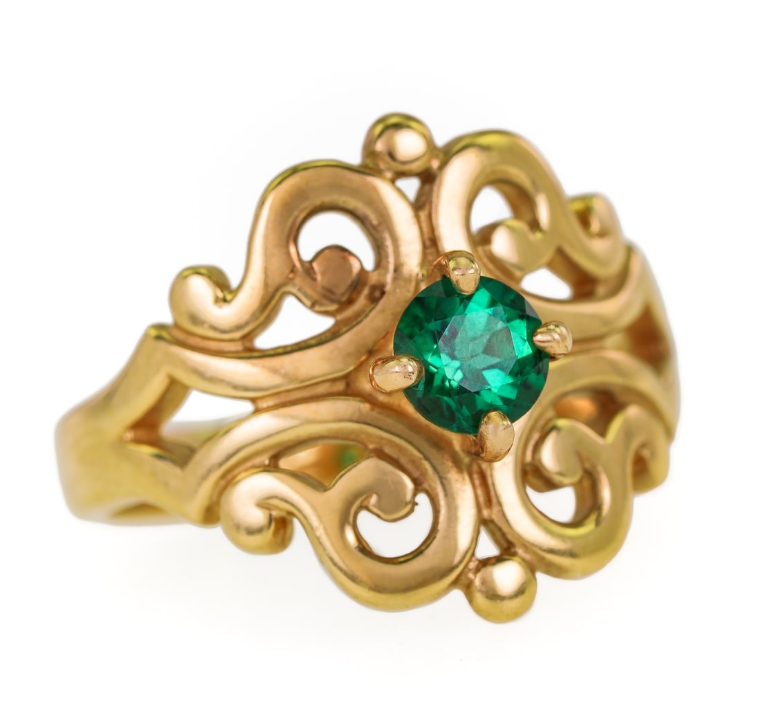 14k & Emerald Ring: 14k yellow gold ring with open work setting having a center round cut natural 1/2 ct emerald. Ring size 7.5. 6.1 grams t.w.