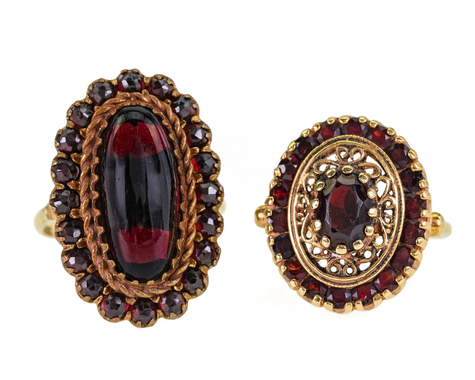 2 Victorian Garnet & Gold Rings: 2 Victorian rings. One with oblong polished garnet & small garnet surround, 27 mm long, 14k ring shank, plated mounting, ring size 8. Second ring tests 10k yellow gold with center oval garnet in