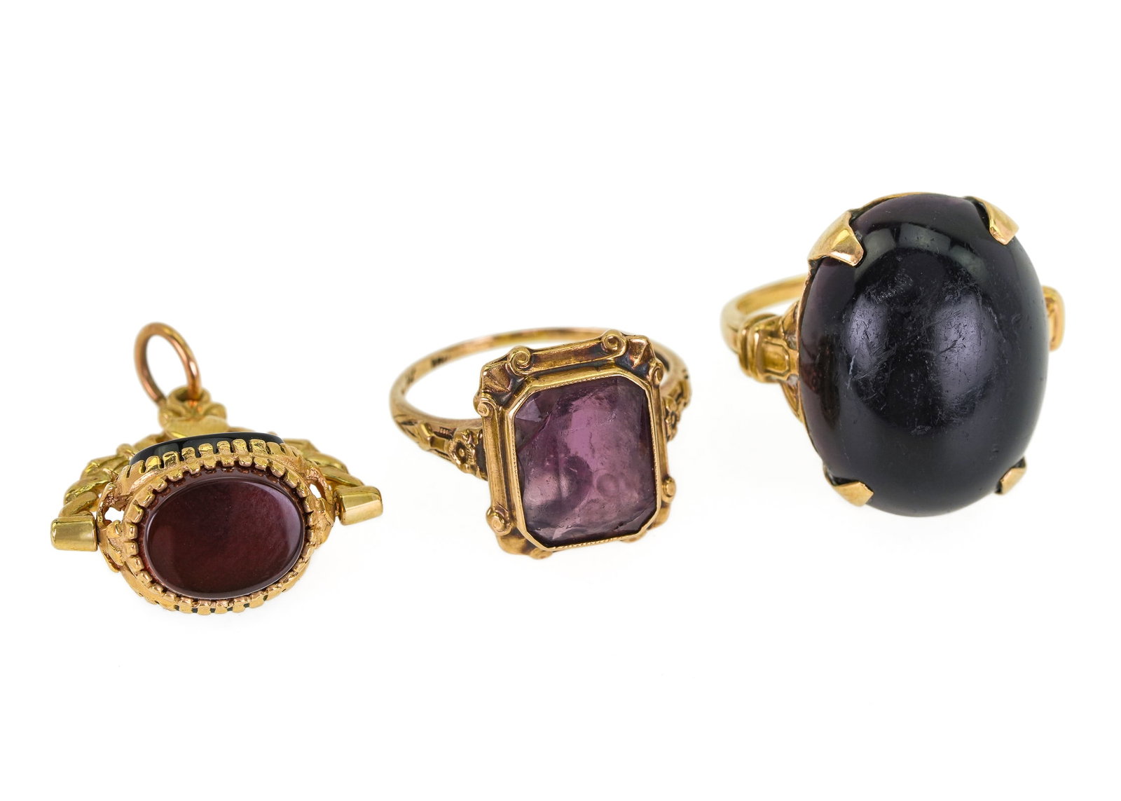 10k Jewelry: 3 piece of 10k yellow gold including ca. 1900 ring with polished onyx, Victorian floral design ring with amethyst, and watch fob with 3 revolving polished stone panels.