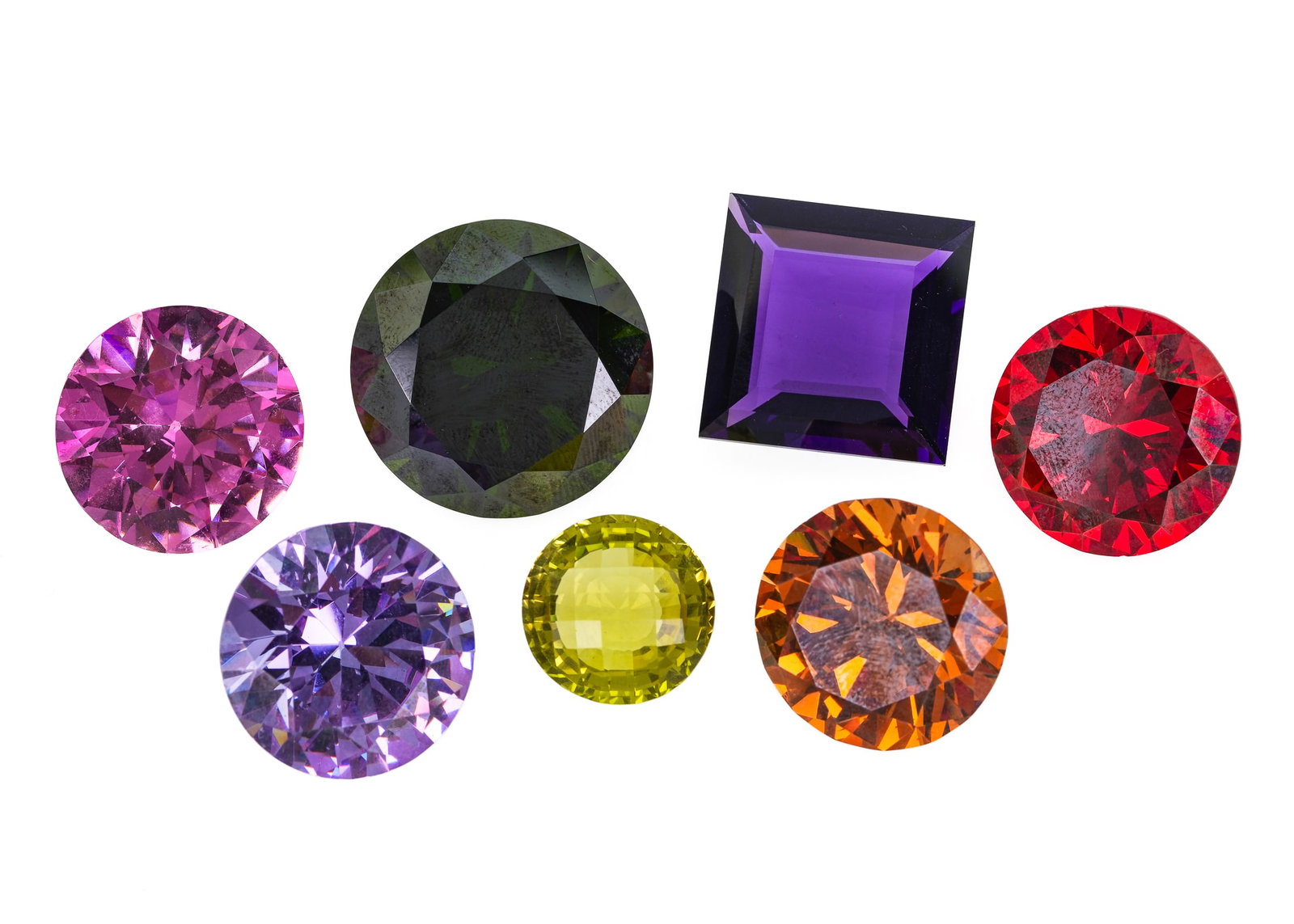 7 Large Cut Polished Quartz: 7 large polished quartz including 30 mm green round cut, 4 25 mm round cut in red, pink, light purple, and amber. 18 mm panel round cut in yellow. 25 mm square cut purple.