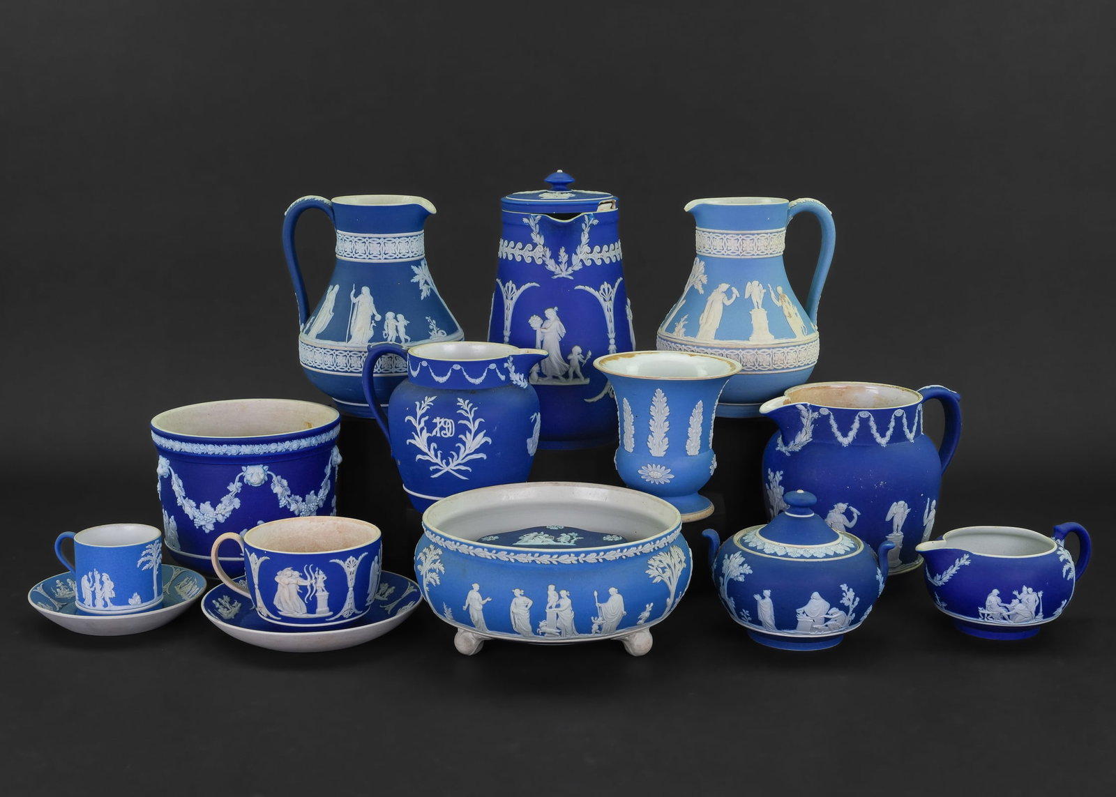 13 pcs. Wedgwood Blue Dipped Jasperware: Collection of 13 pcs. of Late 19th-early 20th c. Wedgwood light and dark cobalt blue dipped jasperware including two pitchers, covered coffee pot, cache pot planter, footed centerpiece bowl, two