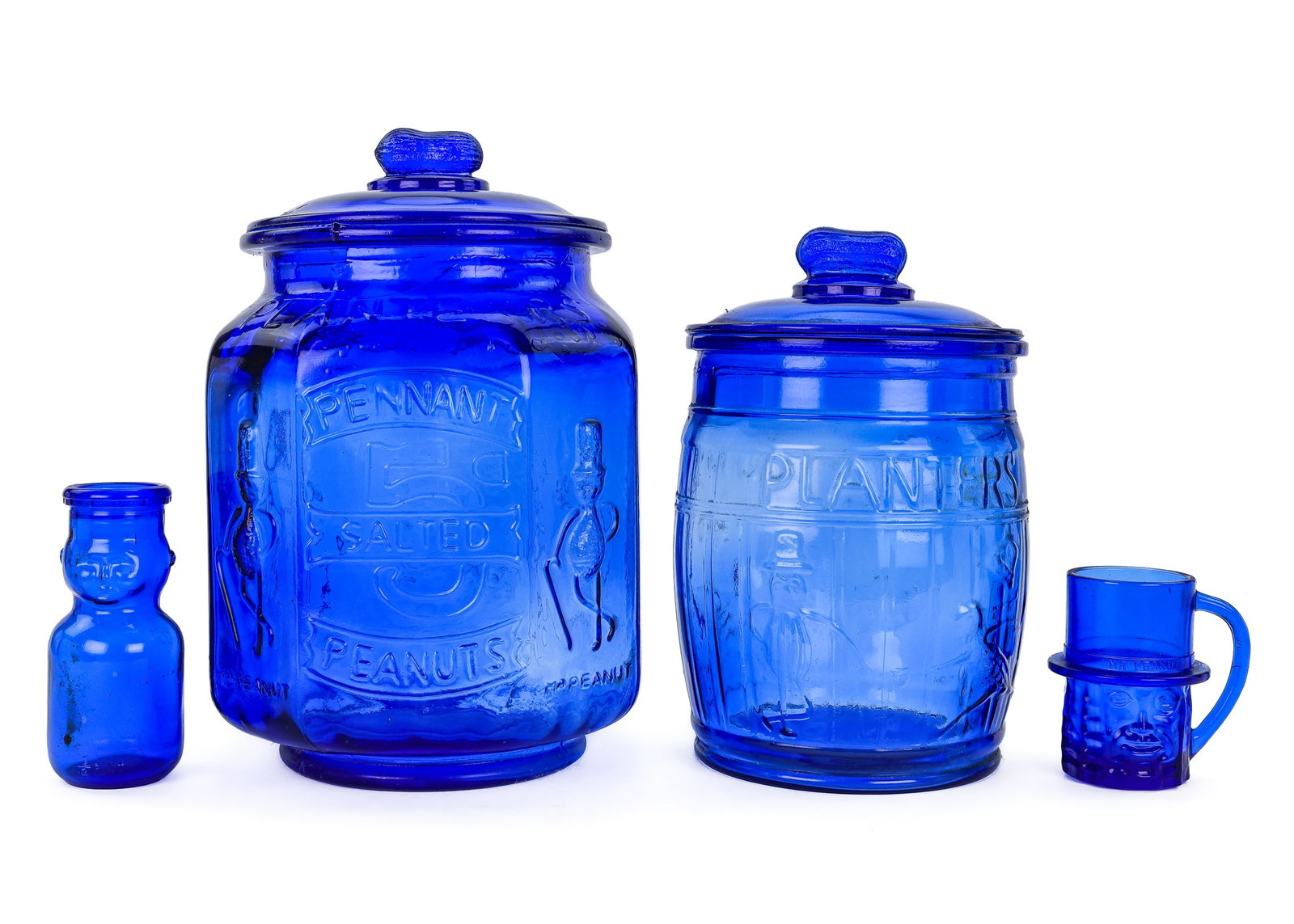 Cobalt Planters Peanut Jars: A group Planters Peanuts cobalt blue depression including a 12" high octagon 5 cent peanut jar. 10" high 5 cent barrel peanut jar. 4" cup with face. And a cream bottle with a baby face.