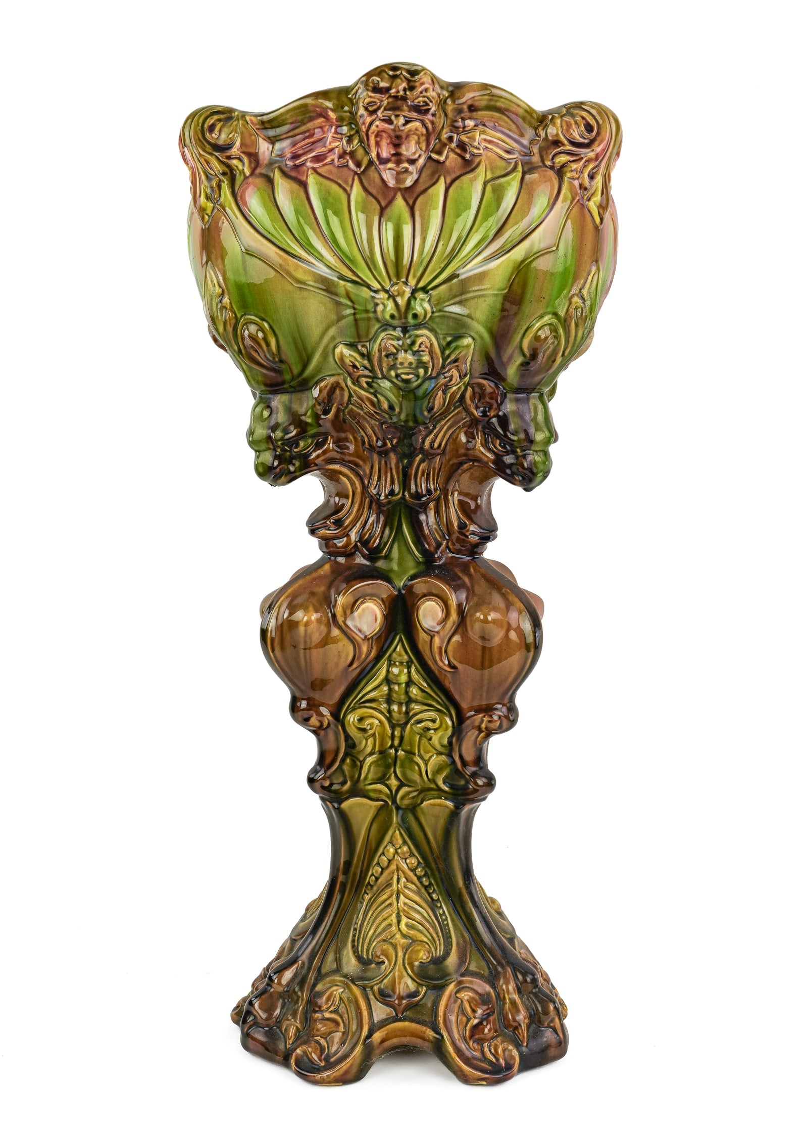 Lions Head Majolica Pottery Jardiniere: Impressive late 19th c. majolica glazed art pottery one-piece pedestal jardiniere having high relief molded decoration of lion's heads, winged griffins, mythological creatures, in mottled tones of gre