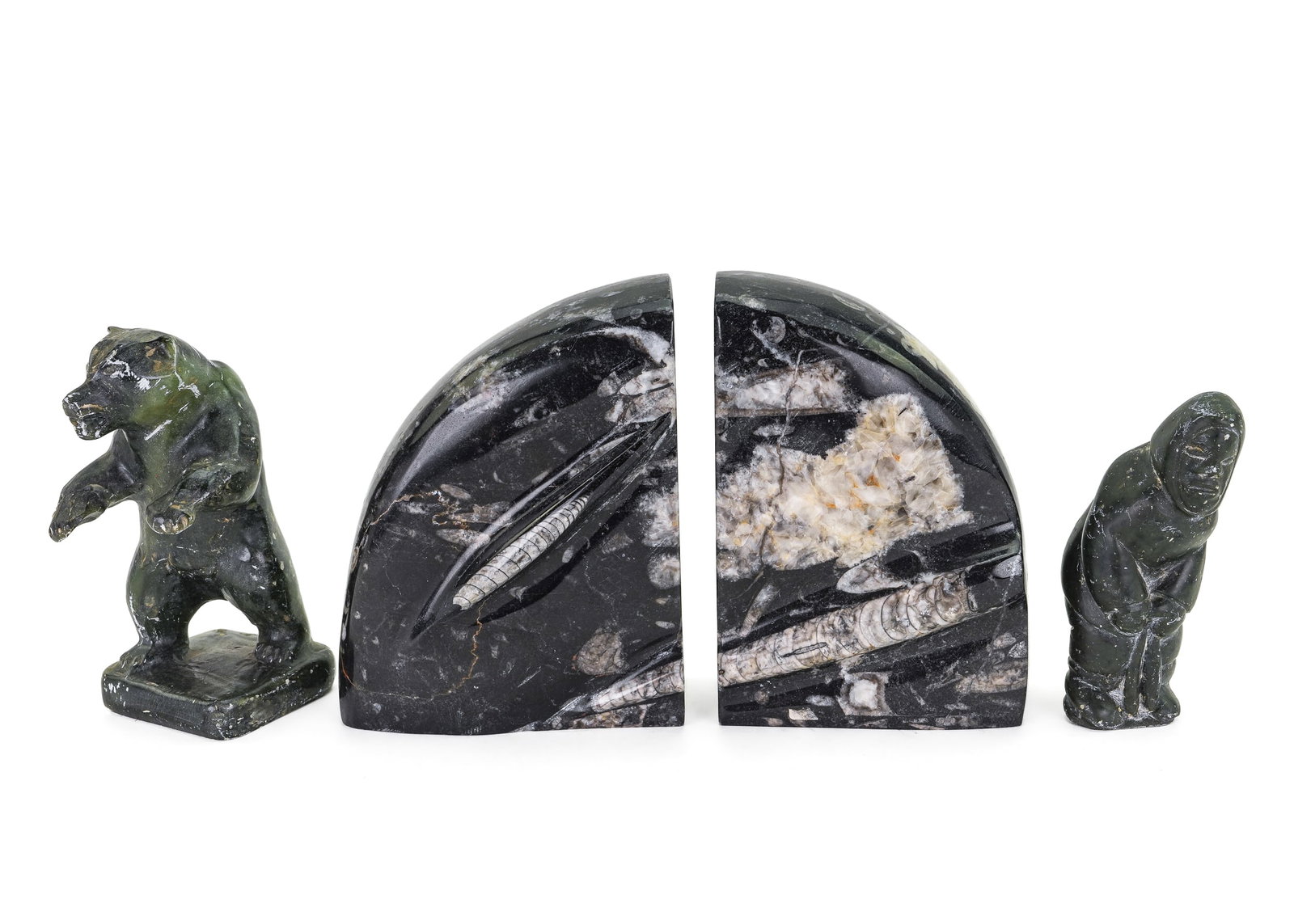 Fossil Bookends, Inuit Soapstone Sculptures: Pair of polished ammonite fossil bookends, accompanied by two Inuit carved soapstone sculptures, one of bear signed "Luke", the other of fisherman bearing two fish. Some nicks and scrapes to soapstone