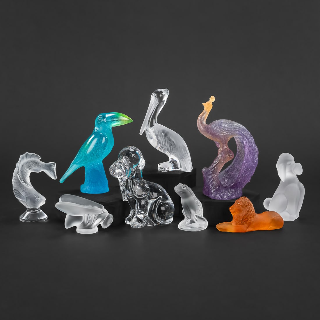 9 French Crystal Figures incl. Daum, Lalique: Group of 9 French crystal figures including Daum Basset hound, Lalique frog, Sevres poodle, colored Daum tucan, colored Daum peacock, Daum pelican, Lalique fish, amber Daum recumbent lion, etc. 2.5"-5