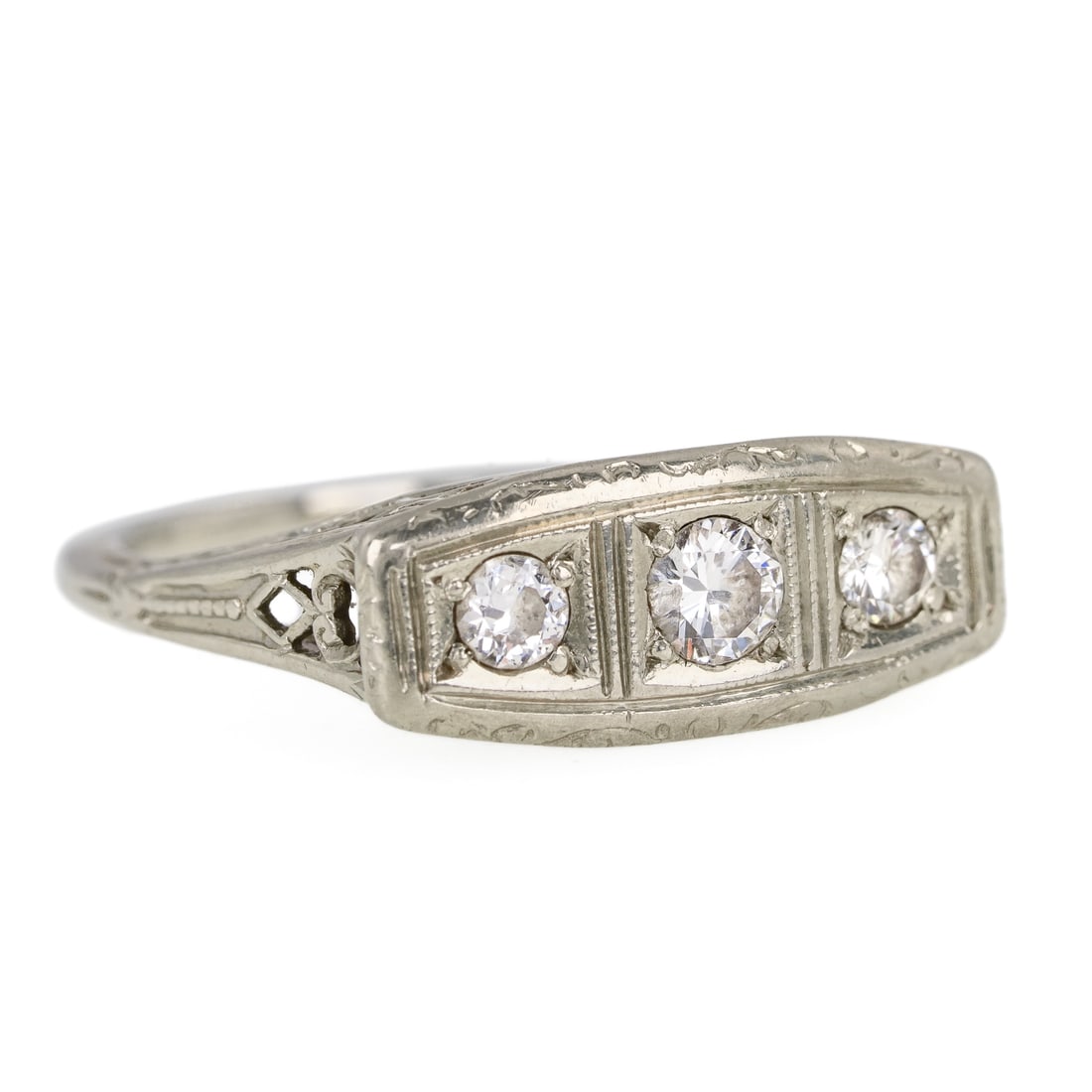 Art Deco 18k 3 Stone Diamond Ring: 18k white gold ring set with 3 European round cut diamonds, 2 - .12 ct, and .15 ct. Open work raised setting with floral detailing. Ring size 5.5. 3.06 grams t.w.