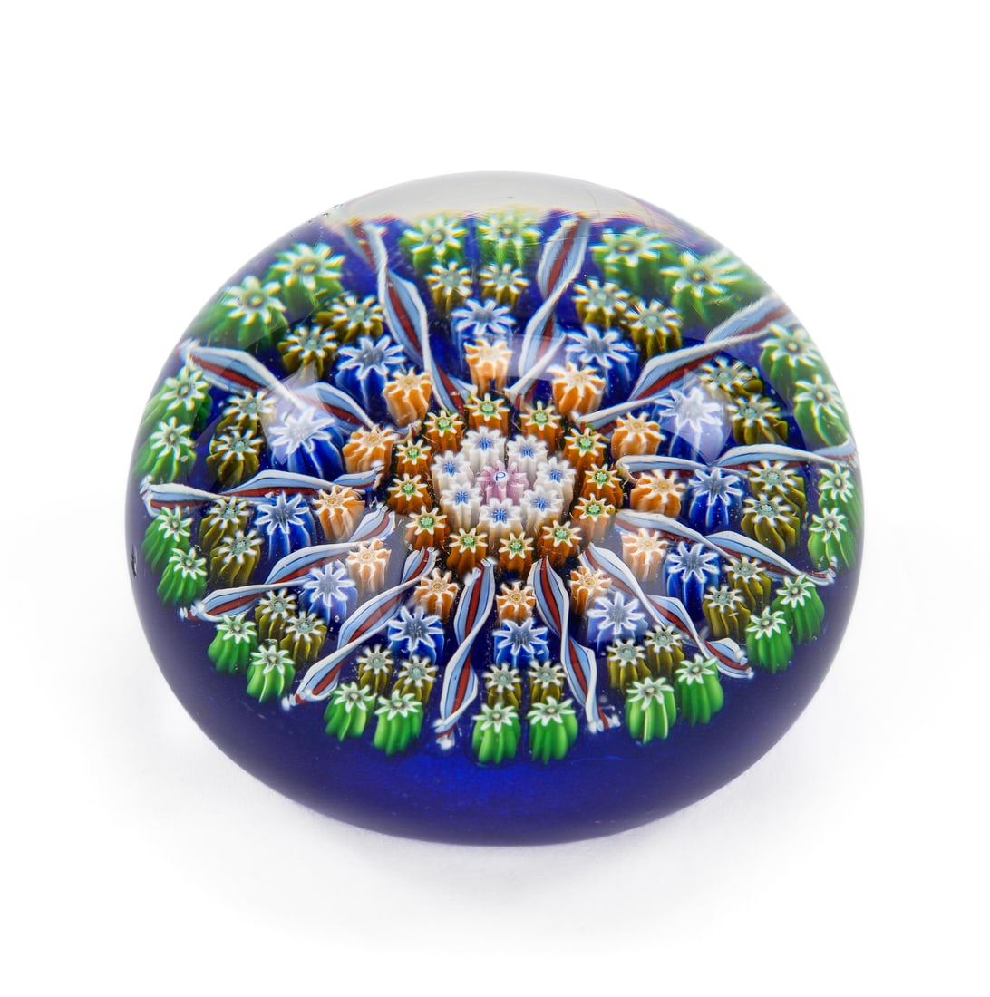 Millefiori Art Glass Paperweight with Twist Canes: Millefiori art glass paperweight with cobalt ground and latticino striped twist cane rays. Fleabite nick to one side. Overall good condition. dia. 3"