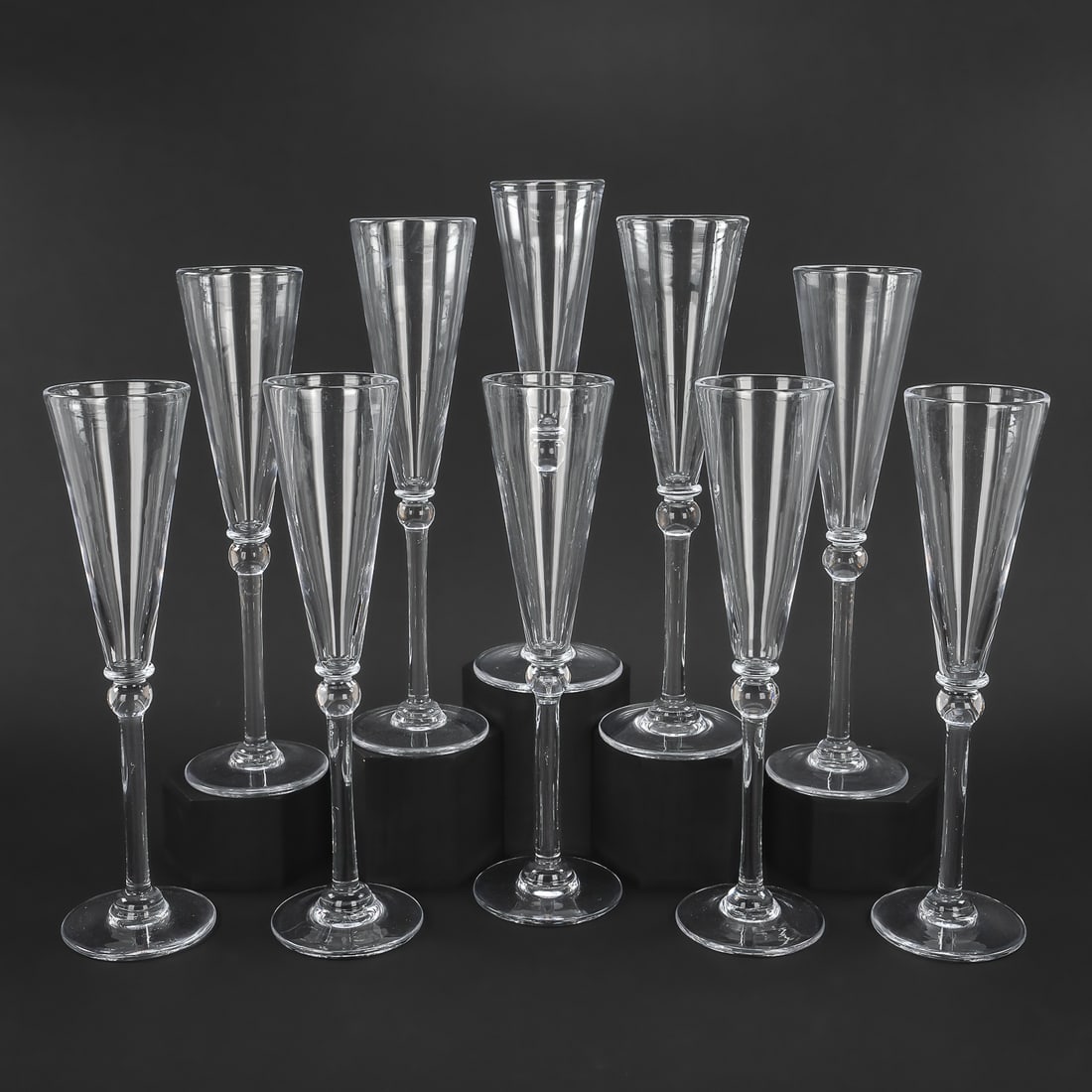 10 Simon Pearce Hartland Champagne Flutes: Set of 10 signed Simon Pearce Quechee, VT "Hartland" pattern artisan hand blown champagne flutes having knob stem and signature quatrefoil pontil marks. ht. 11.5"