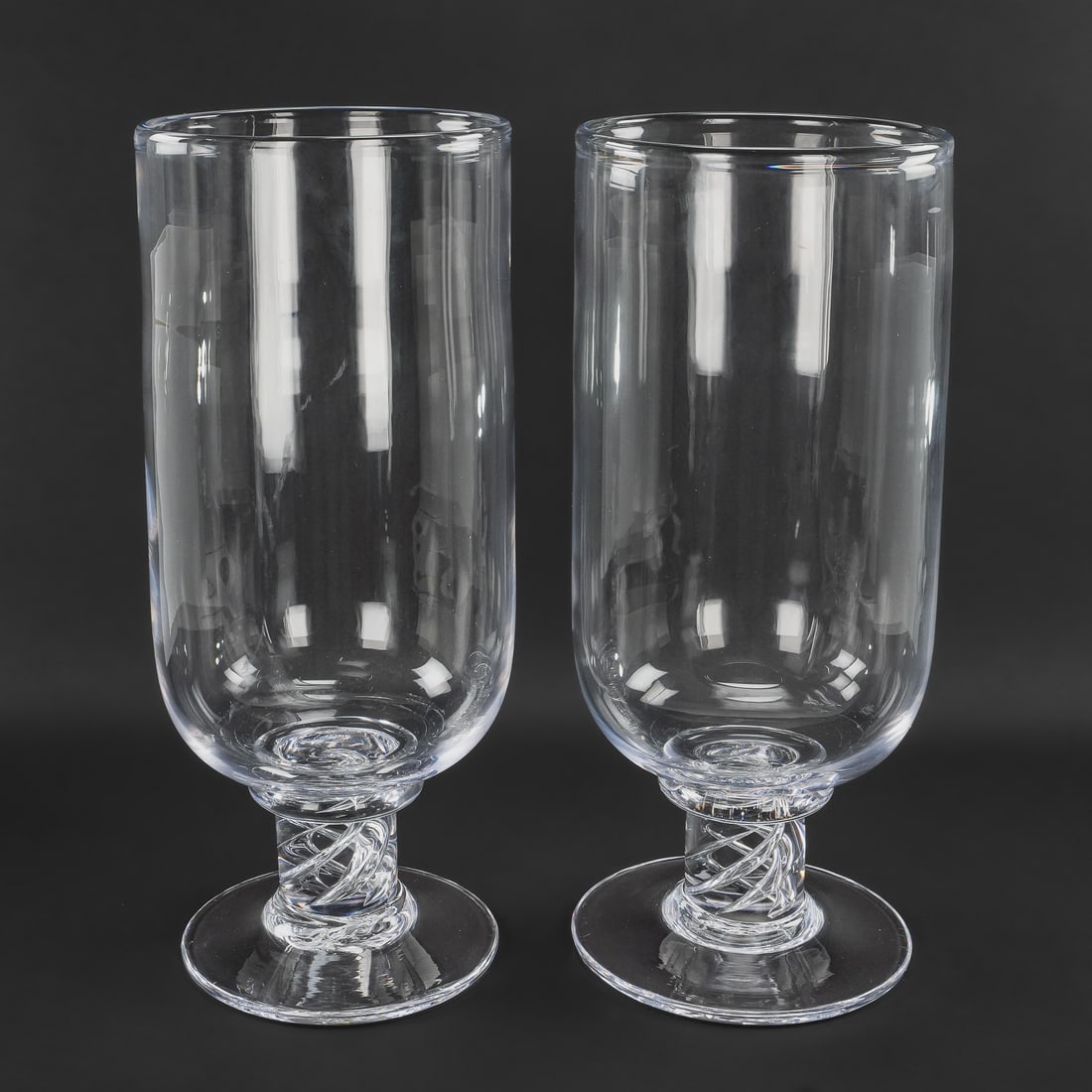 Simon Pearce Stratton Hurricane Lamps: Pair of outstanding signed Simon Pearce Quechee, VT "Stratton" pattern artisan hand blown hurricane globe pillar candle lamps having helical air twist knob stem and signature quatrefoil pontil marks. 