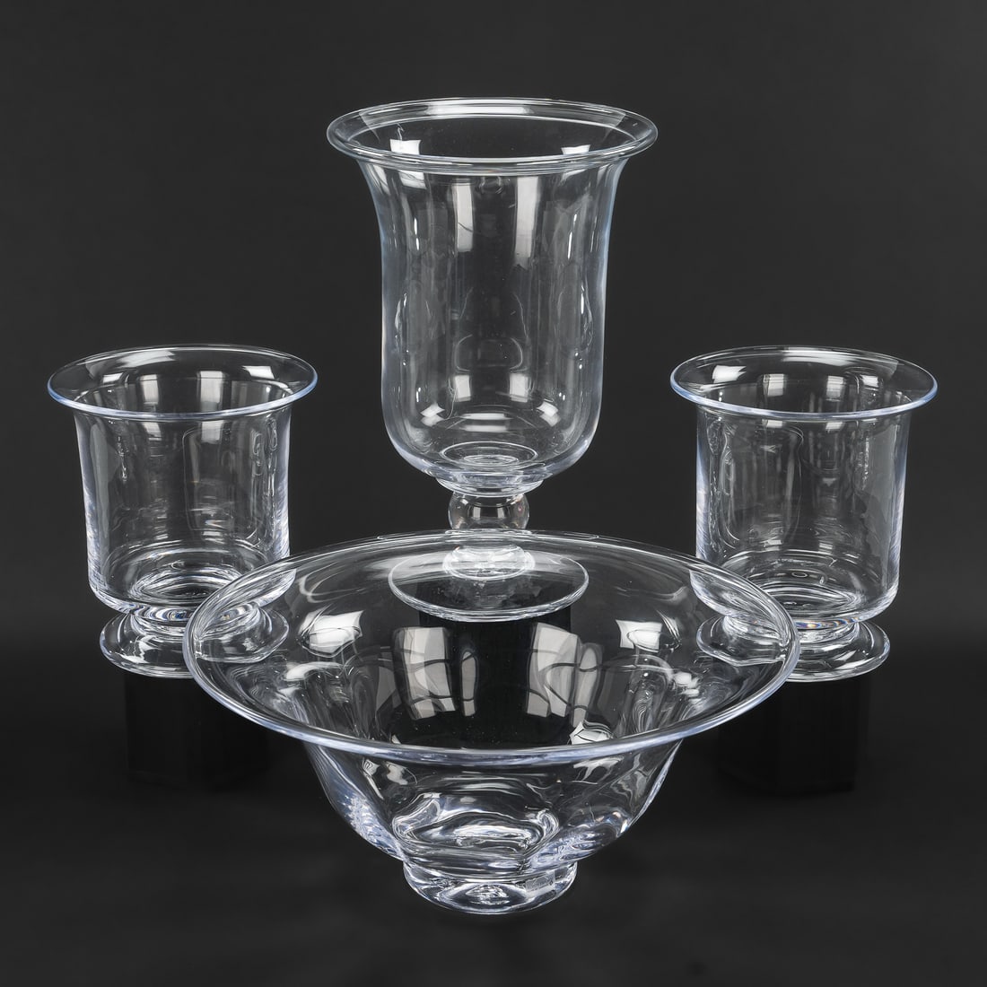 4 pcs. Simon Pearce Crystal Tableware: Group of 4 pcs. Simon Pearce Quechee, VT artisan hand blown tableware including a "Shelburne" centerpiece bowl, a "Revere" large hurricane globe pillar candle lamp, and a matching pair of "Nantucket"