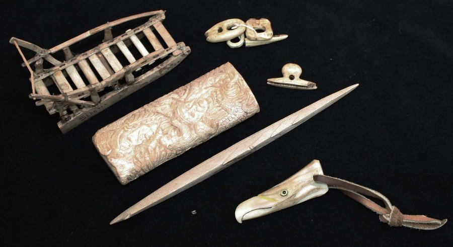 9 Inuit & Native American bone & walrus tusk pieces-: 9 Inuit & Native American bone & walrus tusk pieces- Siberian sled, clothing fasteners, Inuit harpoon tip, eagle effigy w/ glass eyes, carved Indian faces length 1”- 8.5”