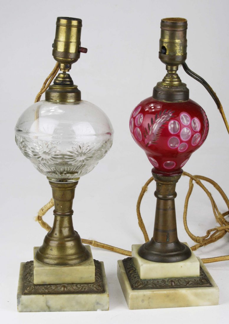 two mid 19th c. oil lamps with brass and marble bases: one with cased cranberry cut to clear font, other with clear pressed glass font ht 11.5"